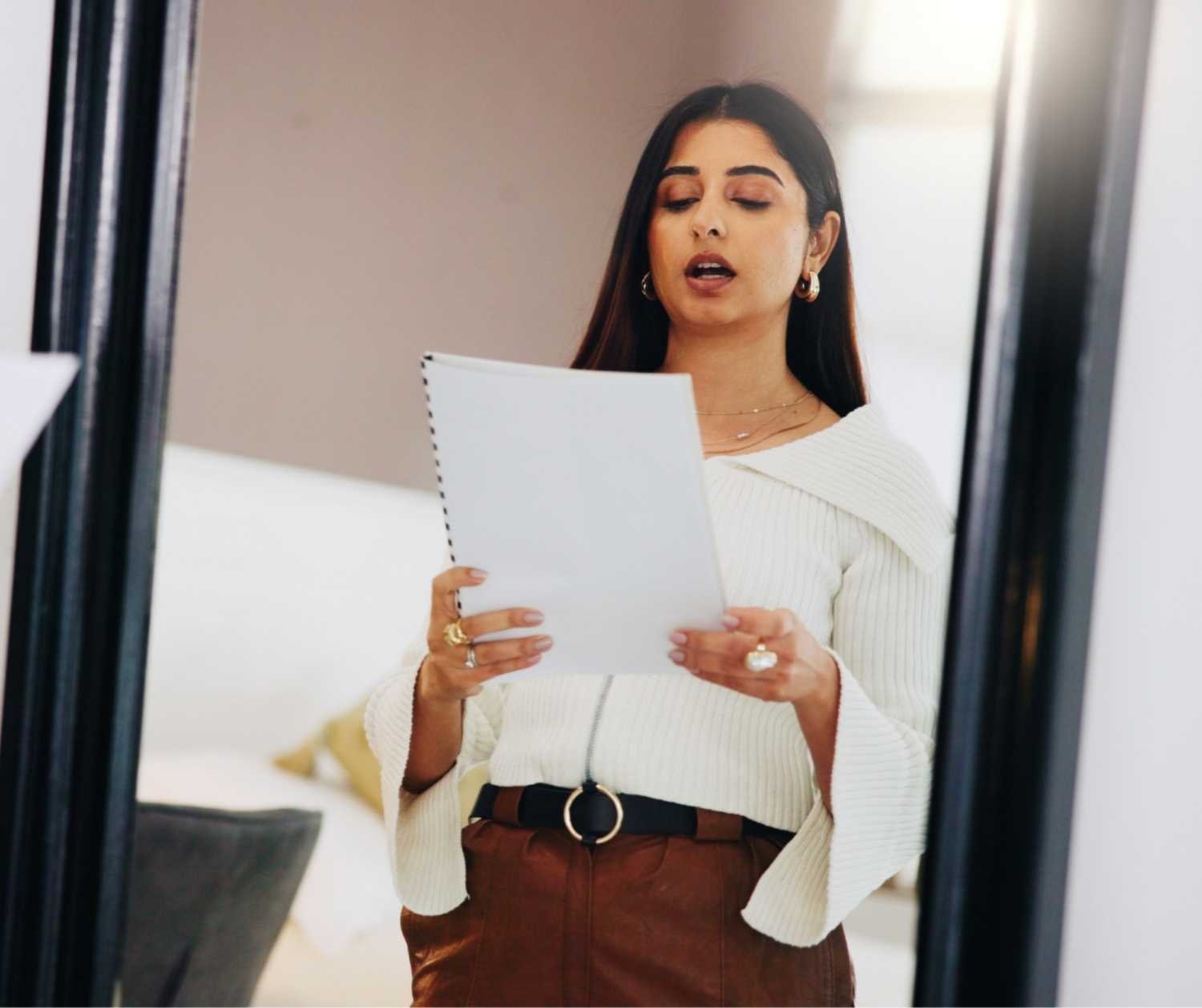 A woman rehearsing interview answers out loud at home