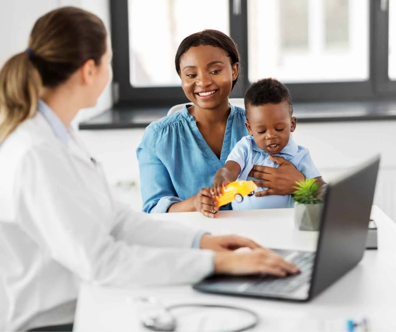 Pediatrician talking with a mother and child in a bright office