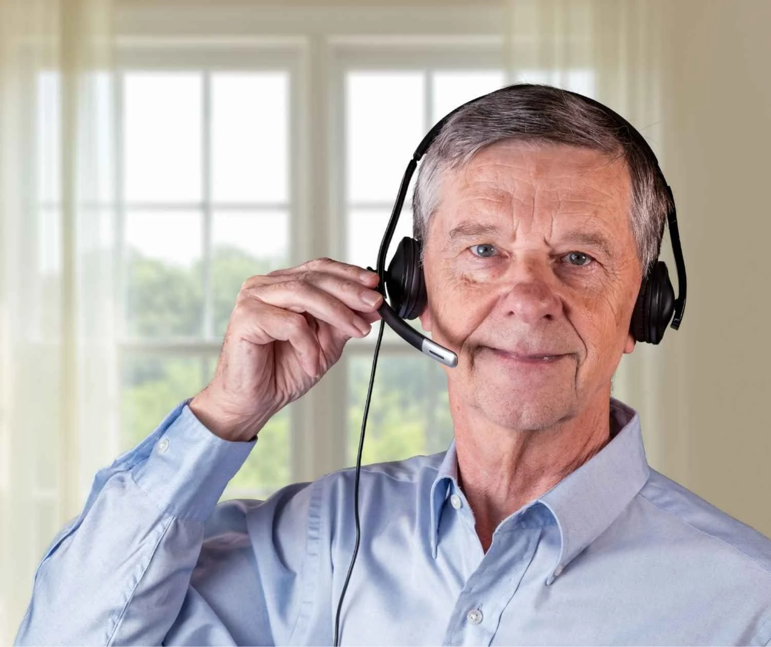Man speaking through a headset microphone at home.