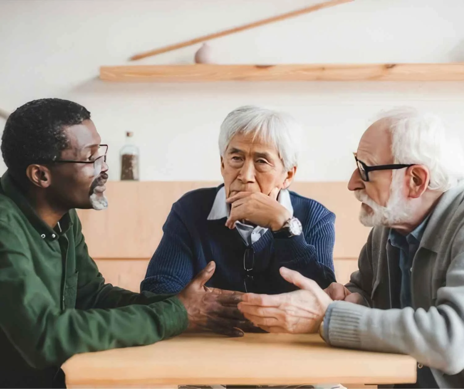 older men mid-conversation at kitchen table, thoughtful