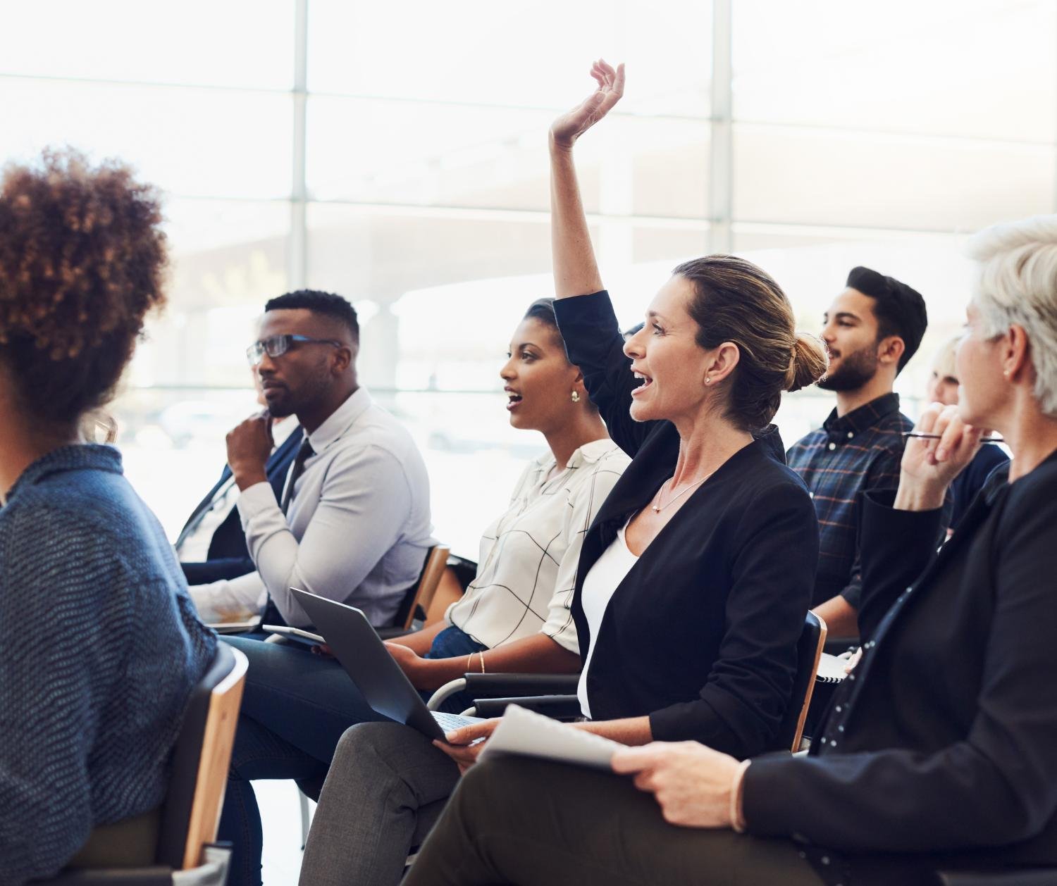 Audience with a woman raising her hand