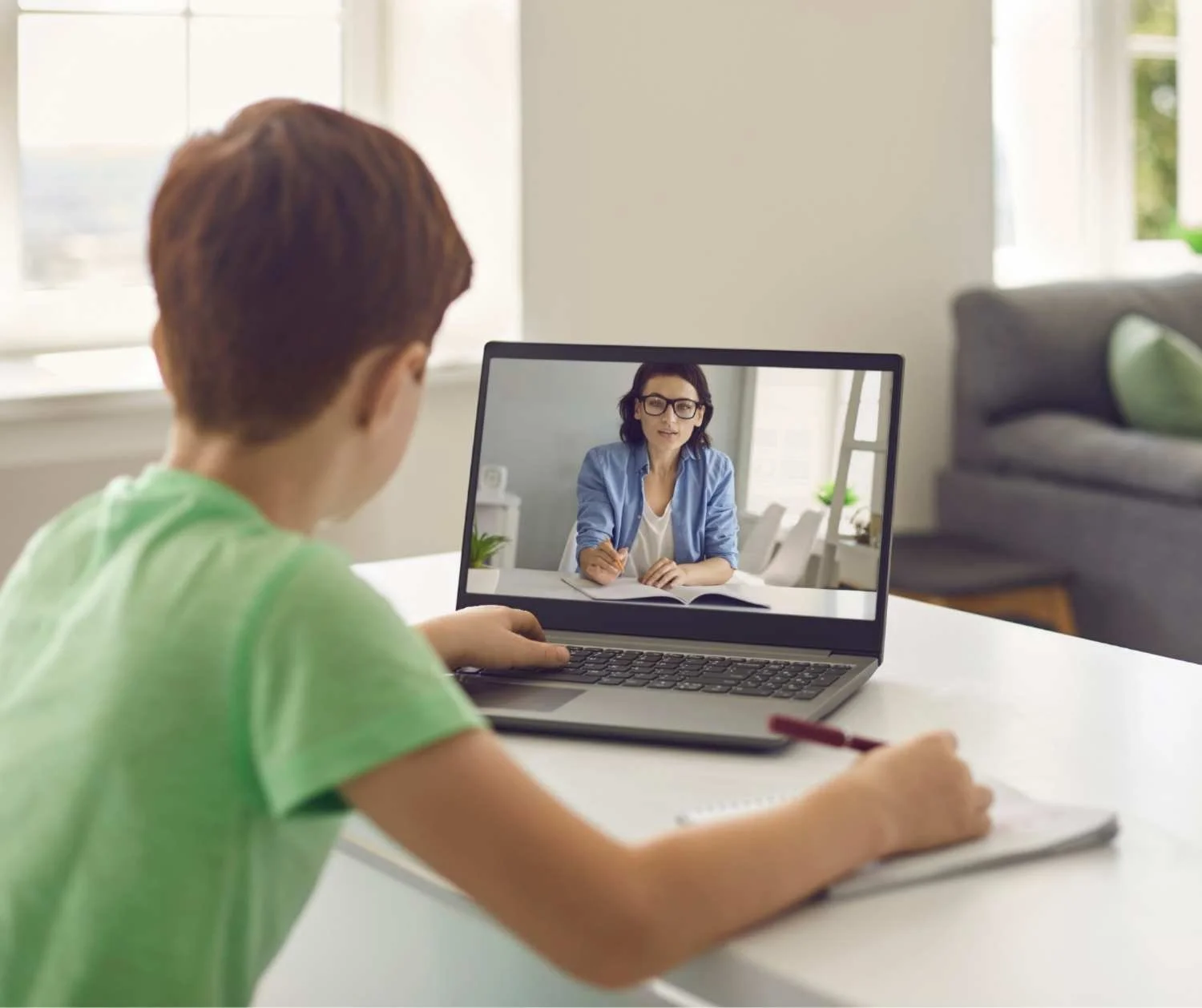 Boy talking with his coach during a live online session at home