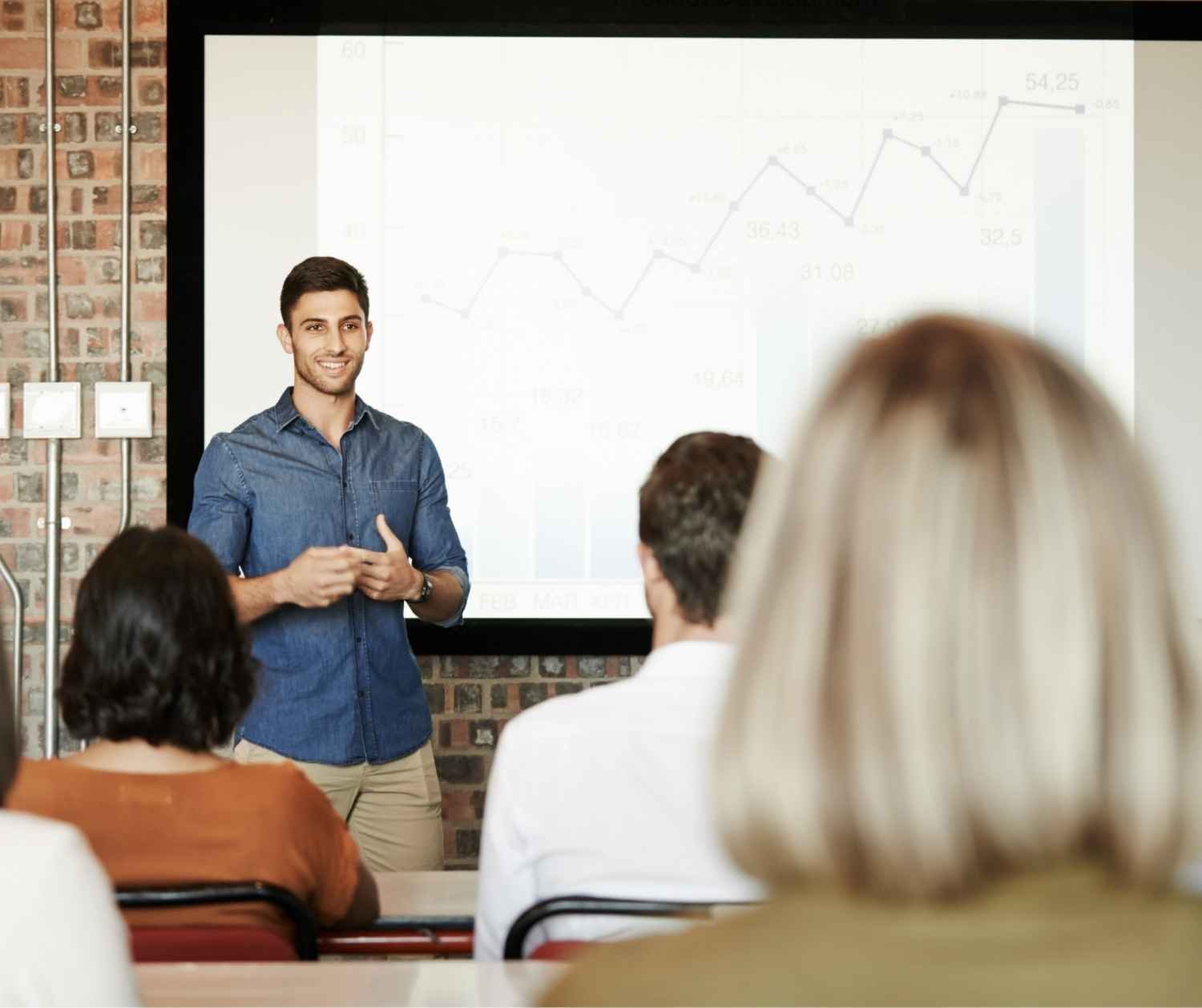 Young man presenting his research to a small audience.