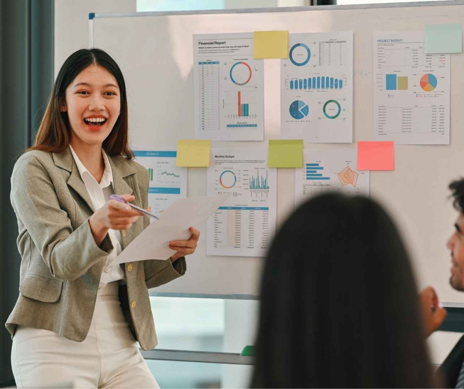 Woman giving a short update to colleagues around a meeting table