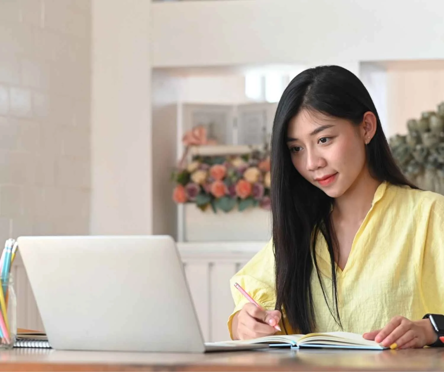 adult taking notes while listening on a video call