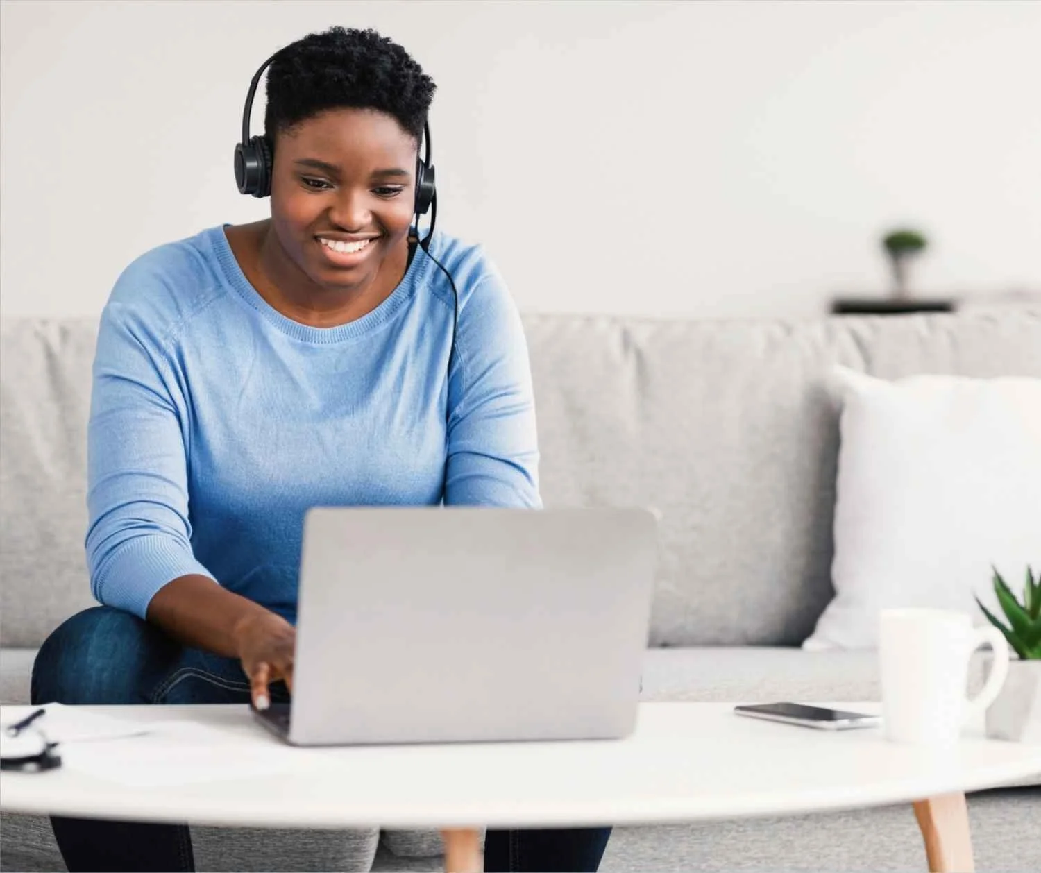 a woman in her 40s wearing noise-canceling headphones while working