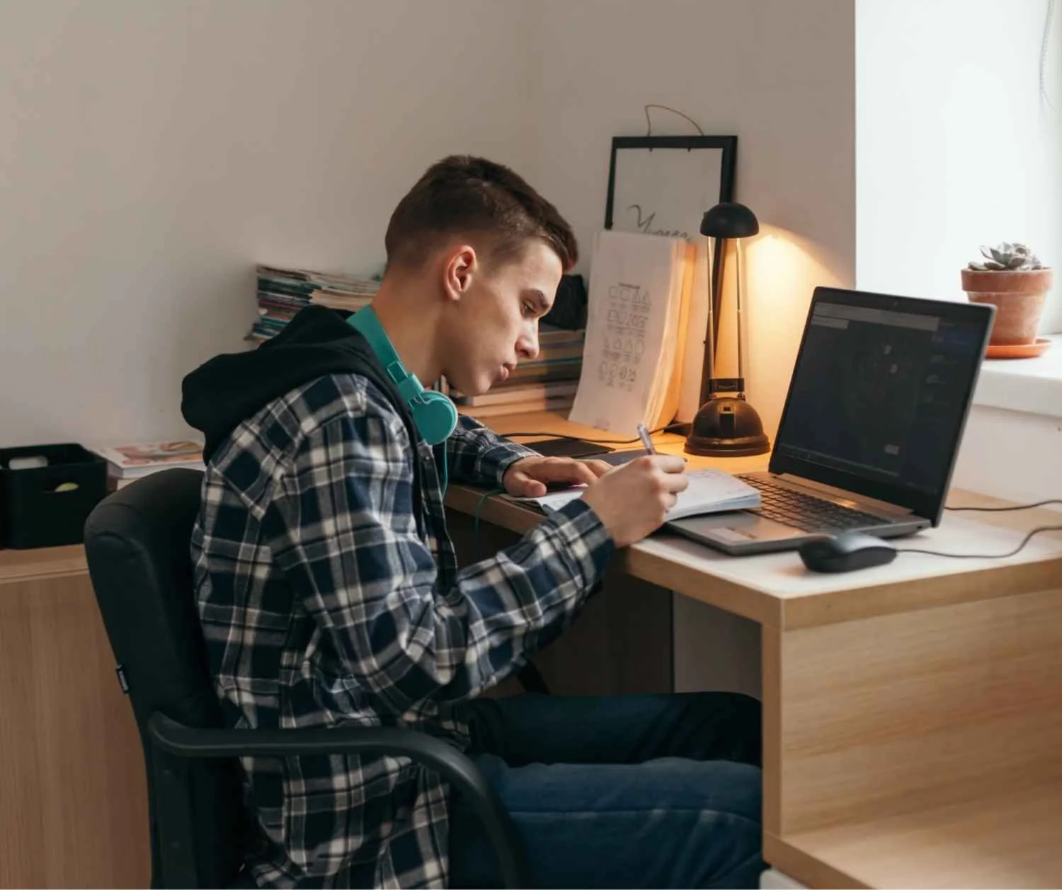 Teenage boy talking during a video session at her desk at home