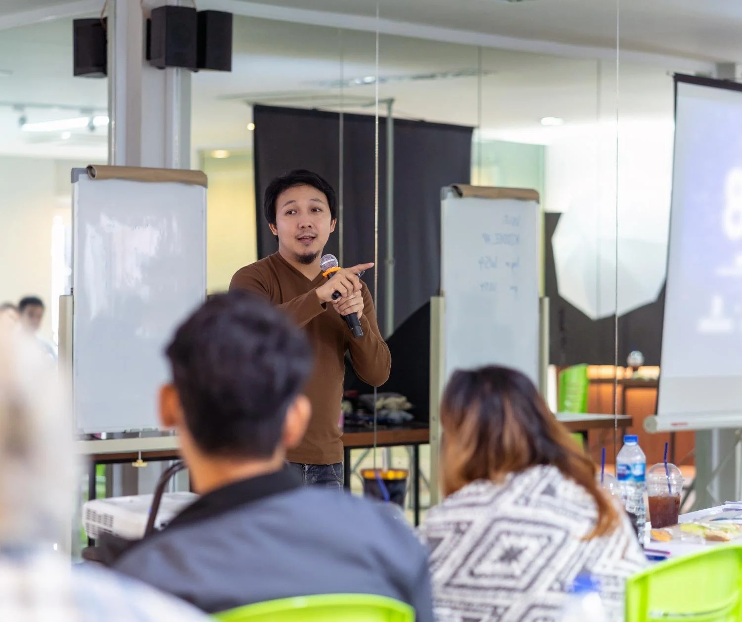 Man presenting at a whiteboard to a seated audience