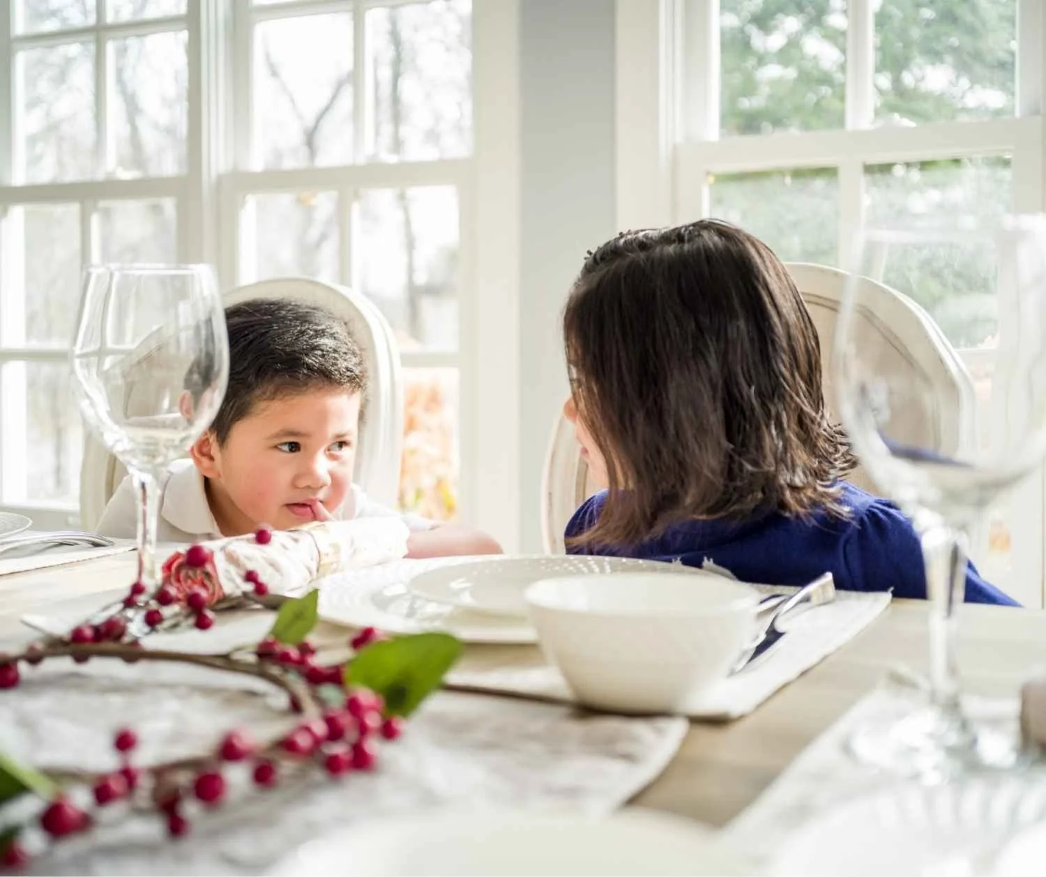 Two children talking at the same time at the family dinner table