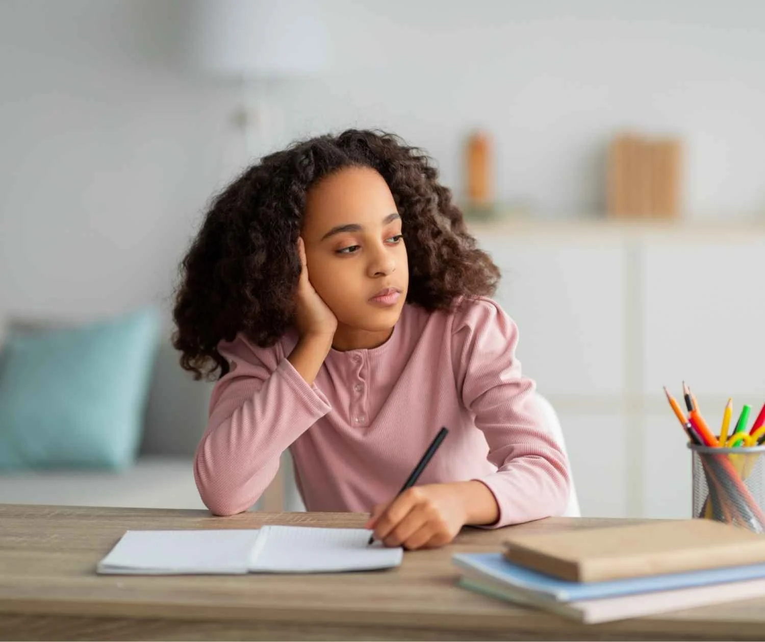 Girl mid thought looking away during homework