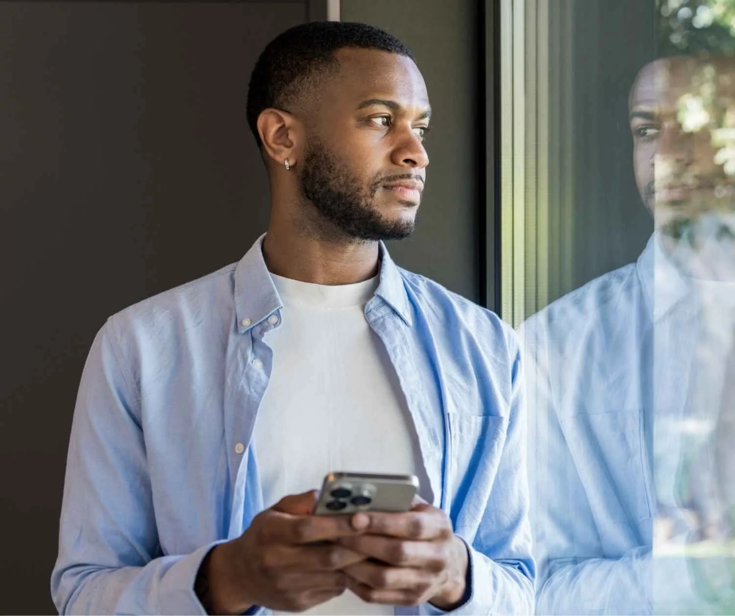 Young man thinking quietly at home by a window.