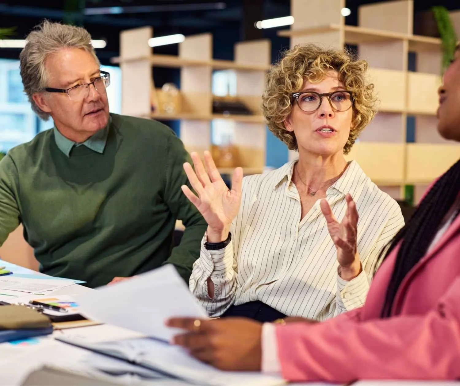Woman explaining a problem to colleagues in a quiet meeting room