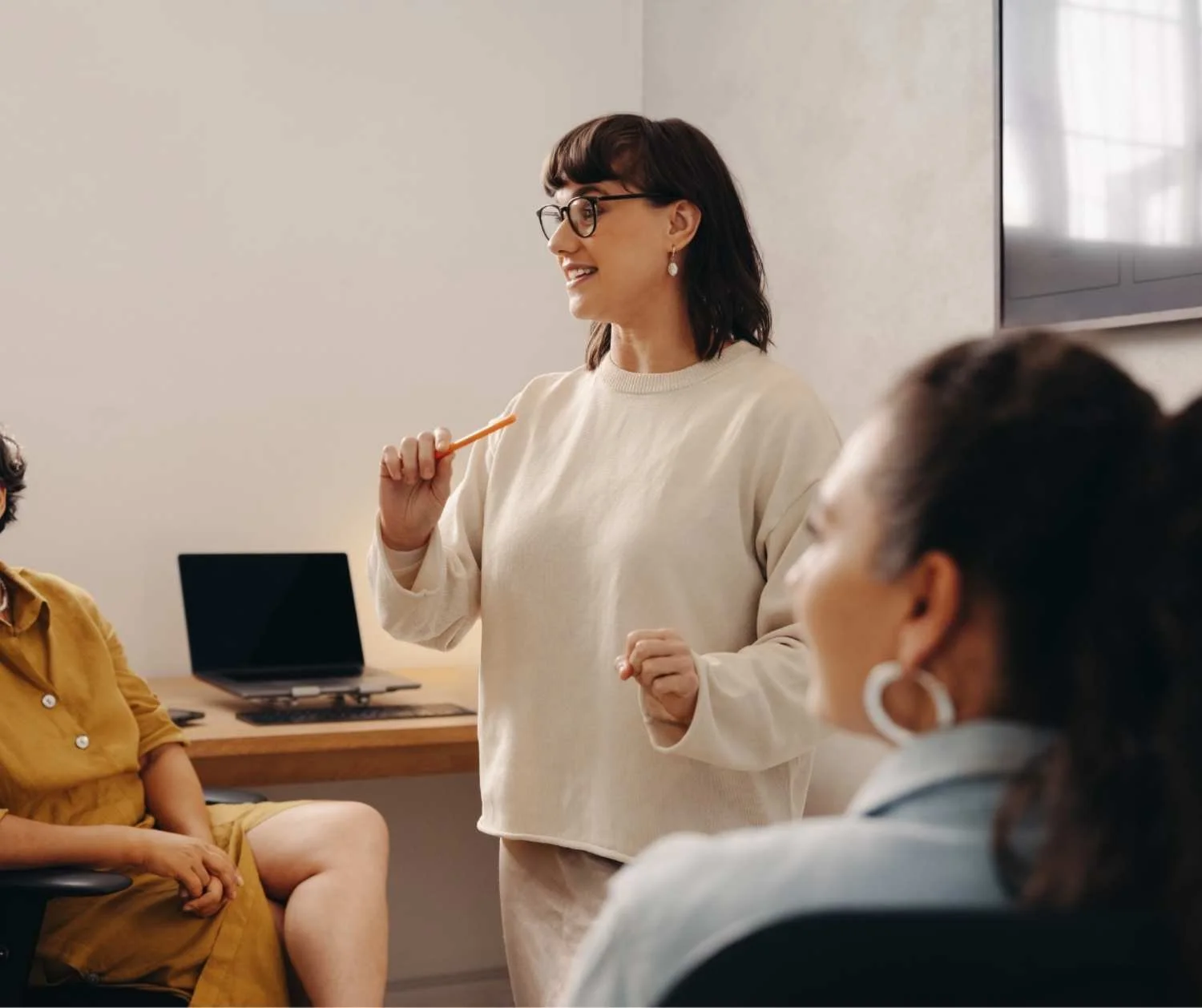 Woman speaking calmly with a coworker in an office.