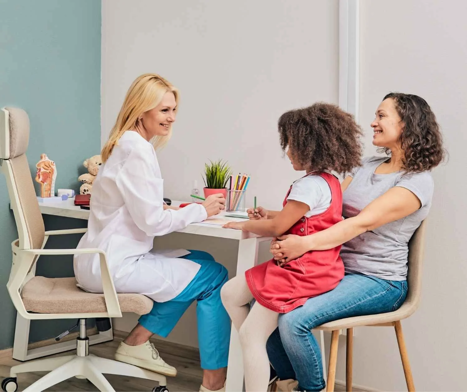 Pediatrician talking with a mother and child in a bright office