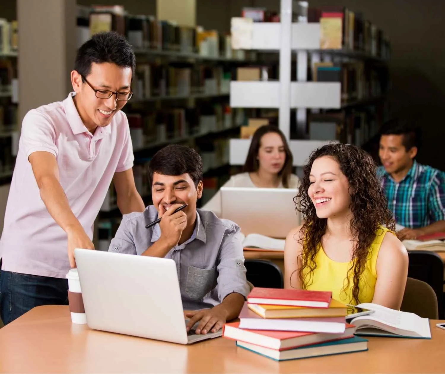Three adults laughing at a library table
