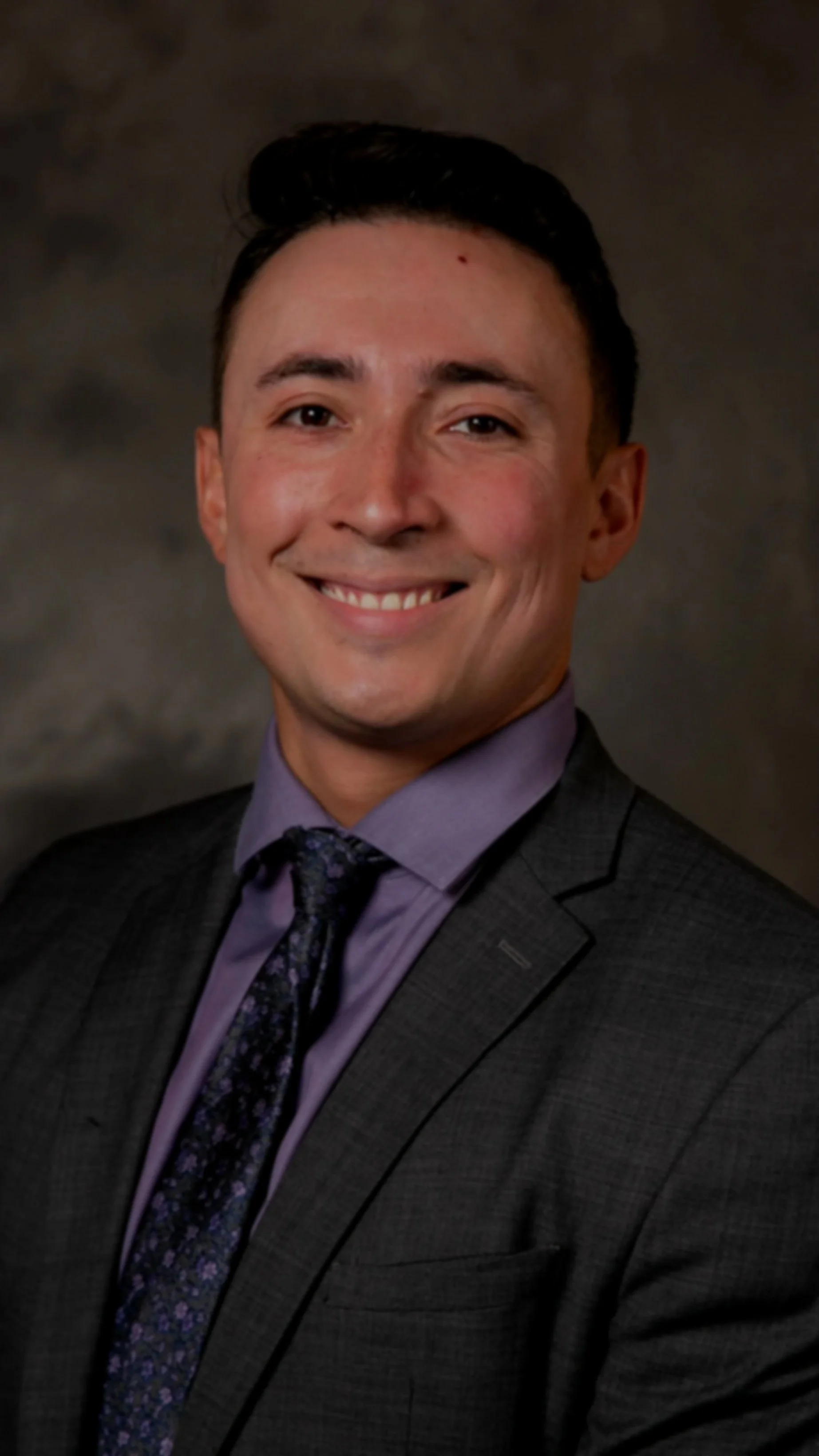 Hunter Parnell, public defender and host of Public Defenseless, smiling in a studio portrait