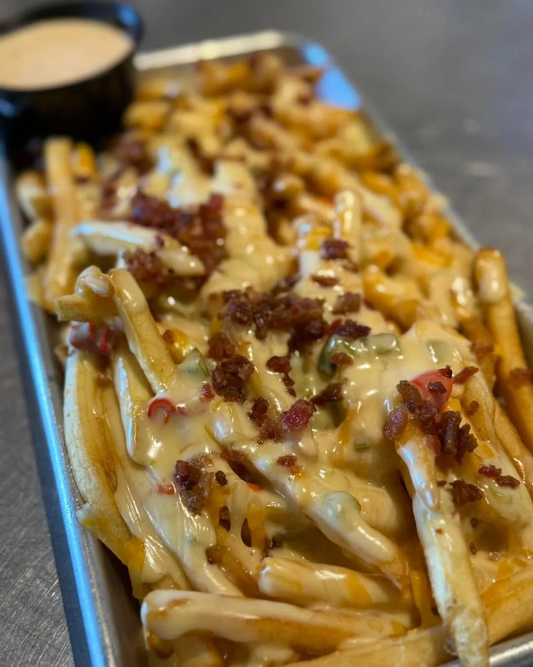 When the temps drop, the flavor turns up. ❄️🔥

Our Queso Fries feature crispy French fries smothered in house-made white queso, melted cheddar-jack, topped with double-smoked bacon, and served with our signature chipotle ranch.

Cold outside. Hot, c