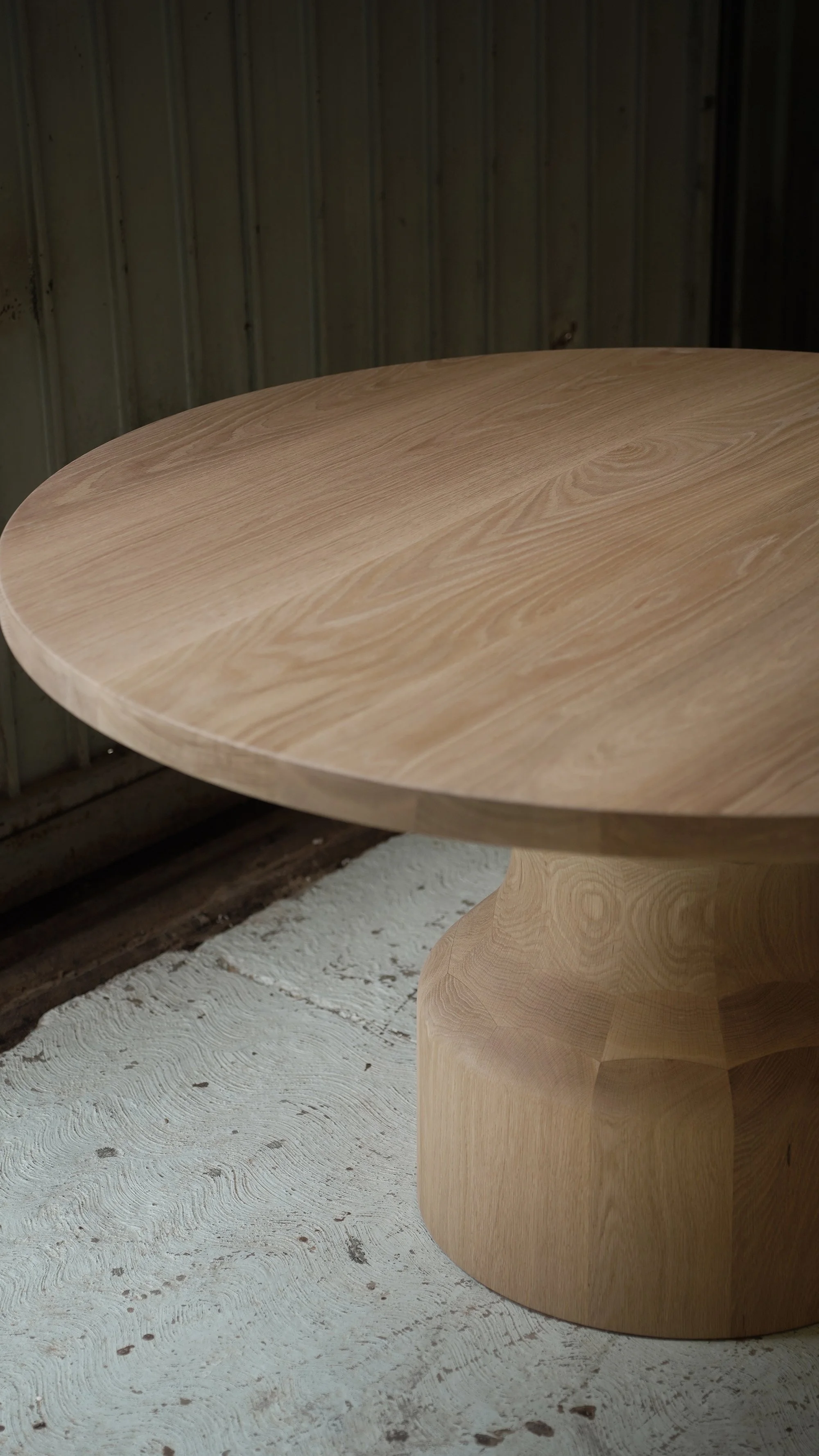 Custom Socle dining table scaled for generous seating and clear circulation around its solid wood base.
