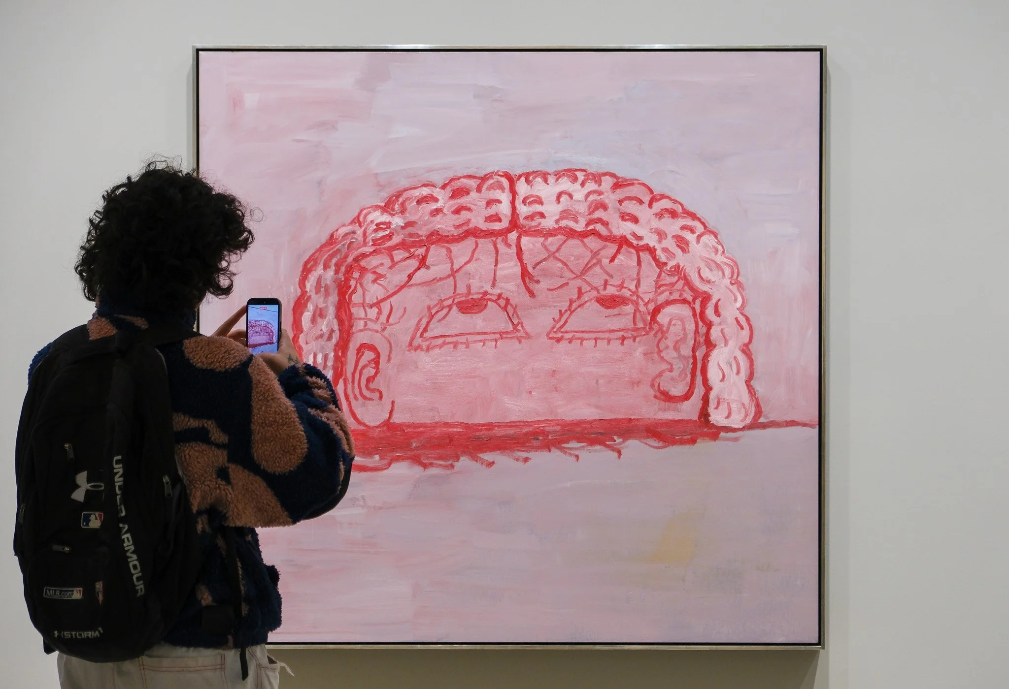 Philip Guston's Untitled 1976 painting showing a head with dense looping hair and upward-tilted eyes.