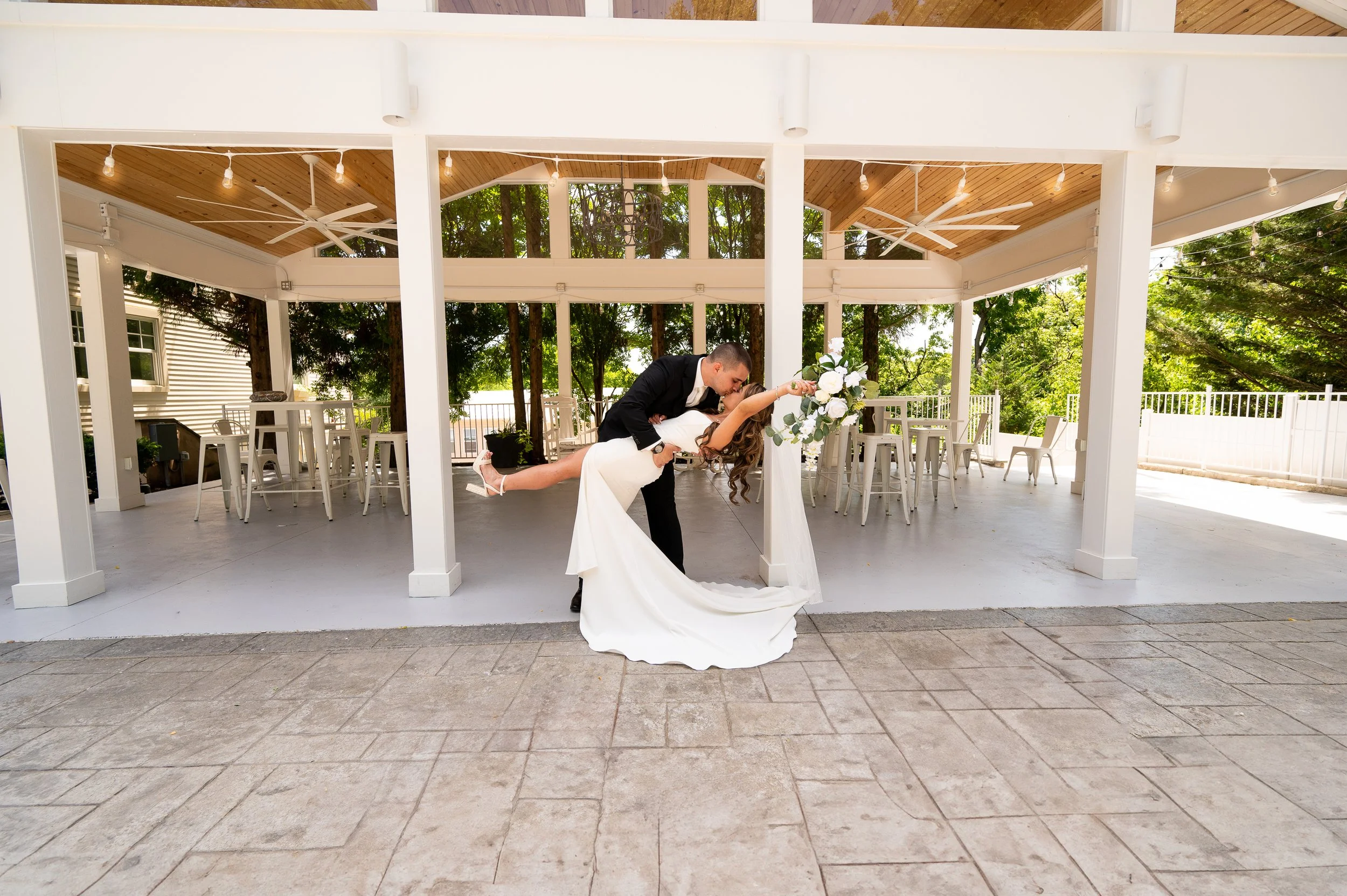 Couple kissing after their outdoor micro wedding at Milton Ridge. Posing during cocktail hour in front of the pavilion on the outdoor patio at Milton Ridge.