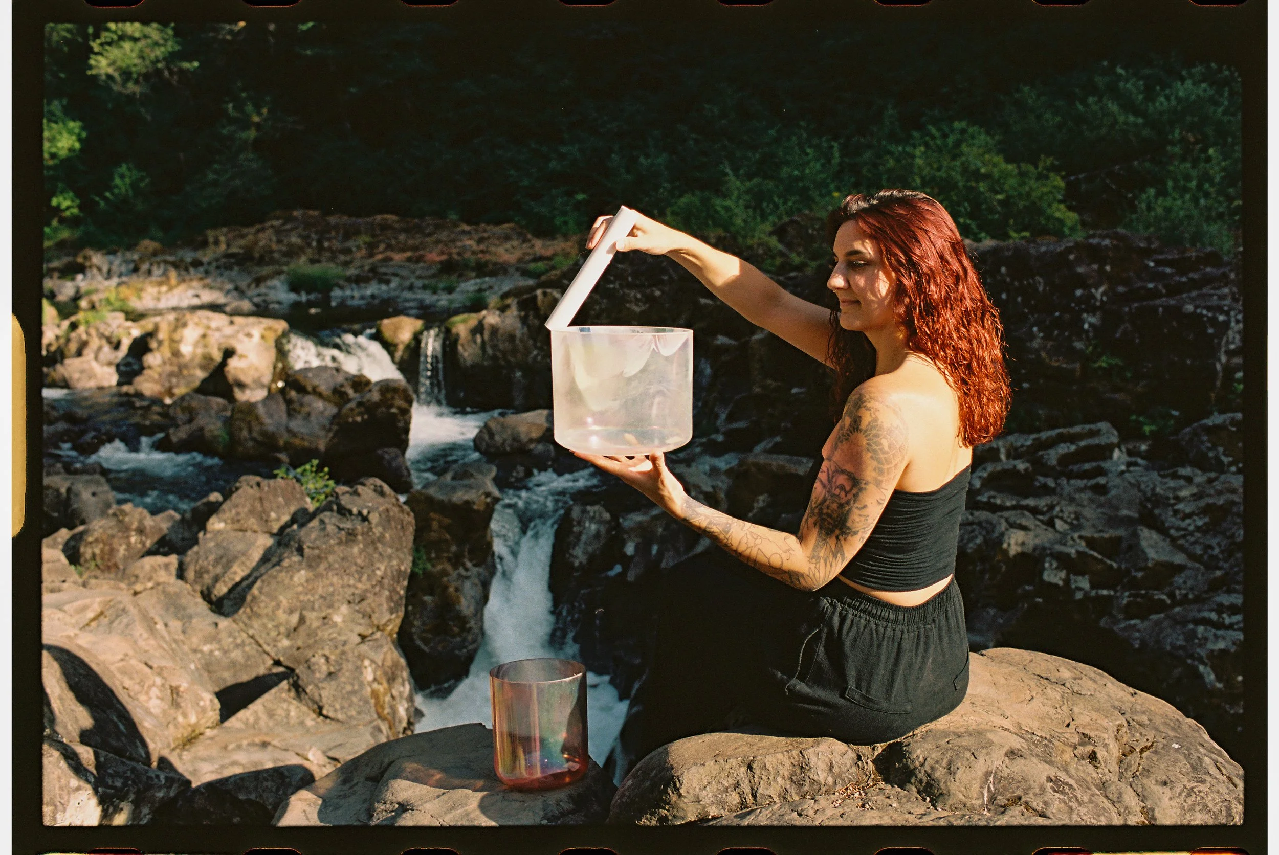 sounder healer playing bowls in front of a waterfall