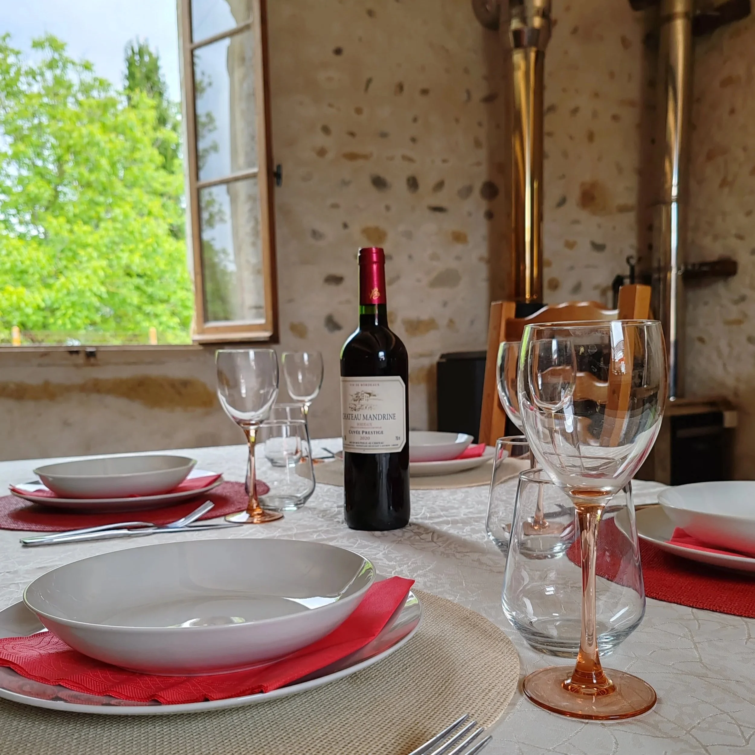 Dining table laid with cutlery, crockery and wine bottle