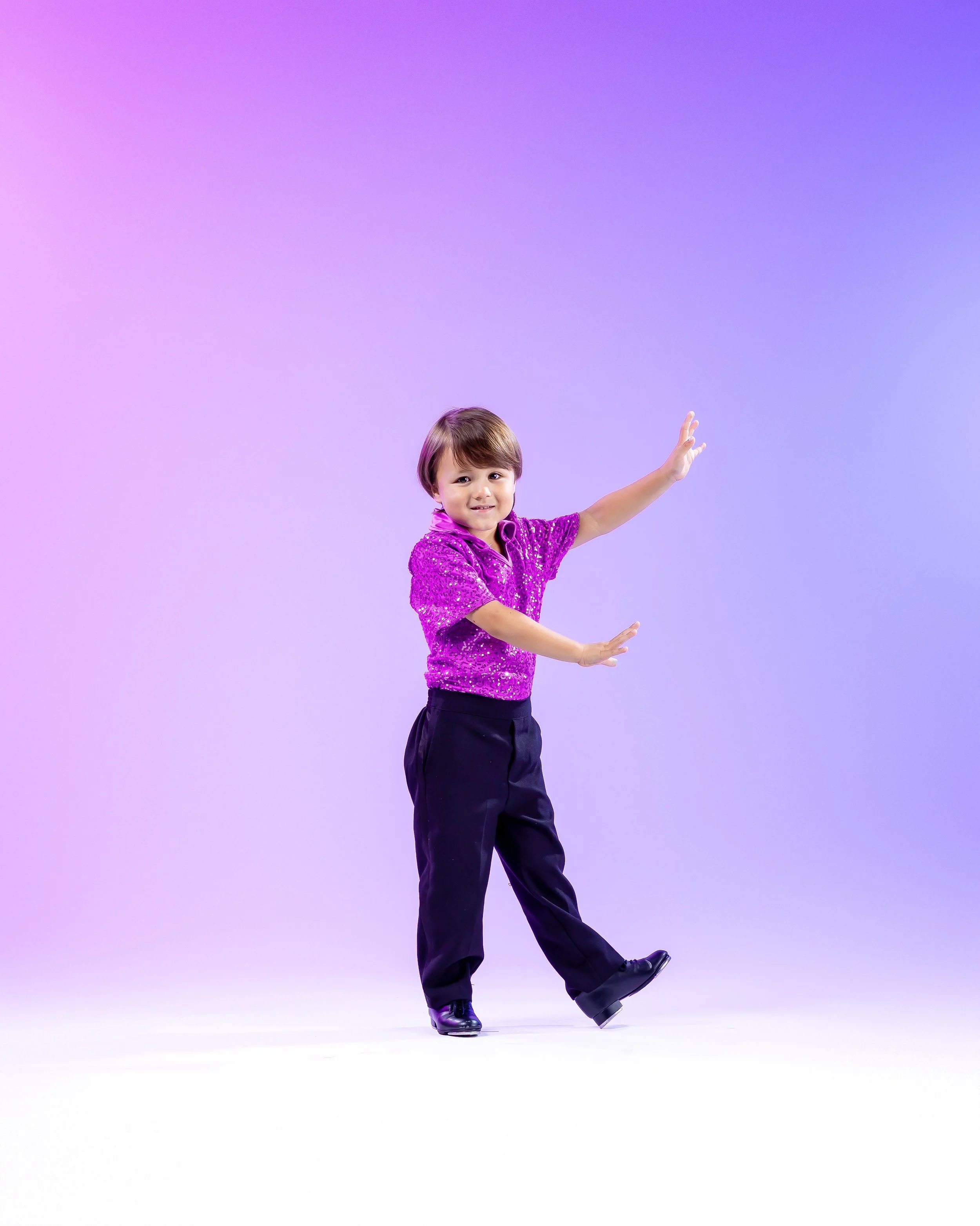 A young boy in figure skating attire poses on an ice rink with a purple gradient background.