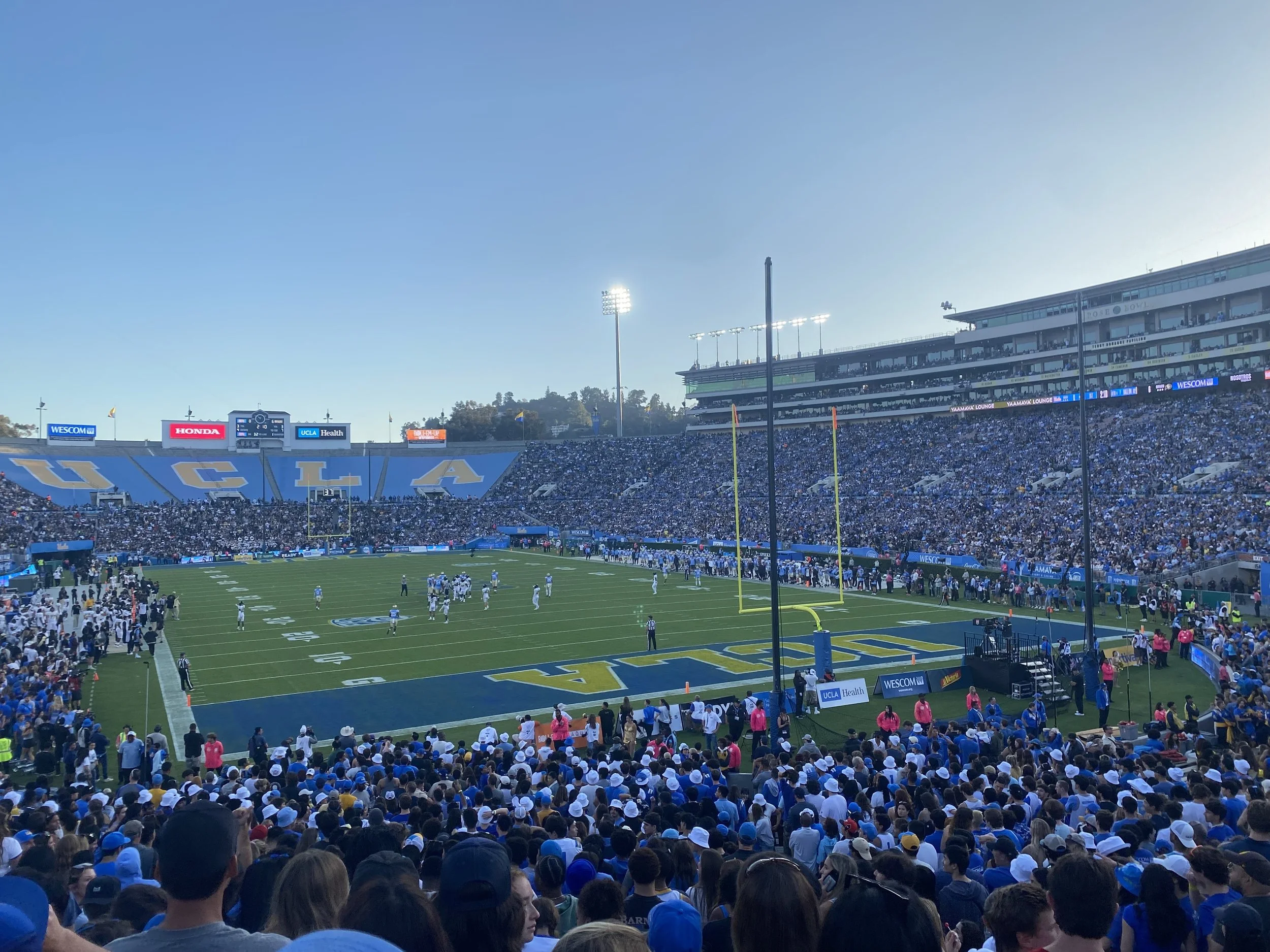 Fans sit in football stadium with UCLA written in yellow in a blue endzone