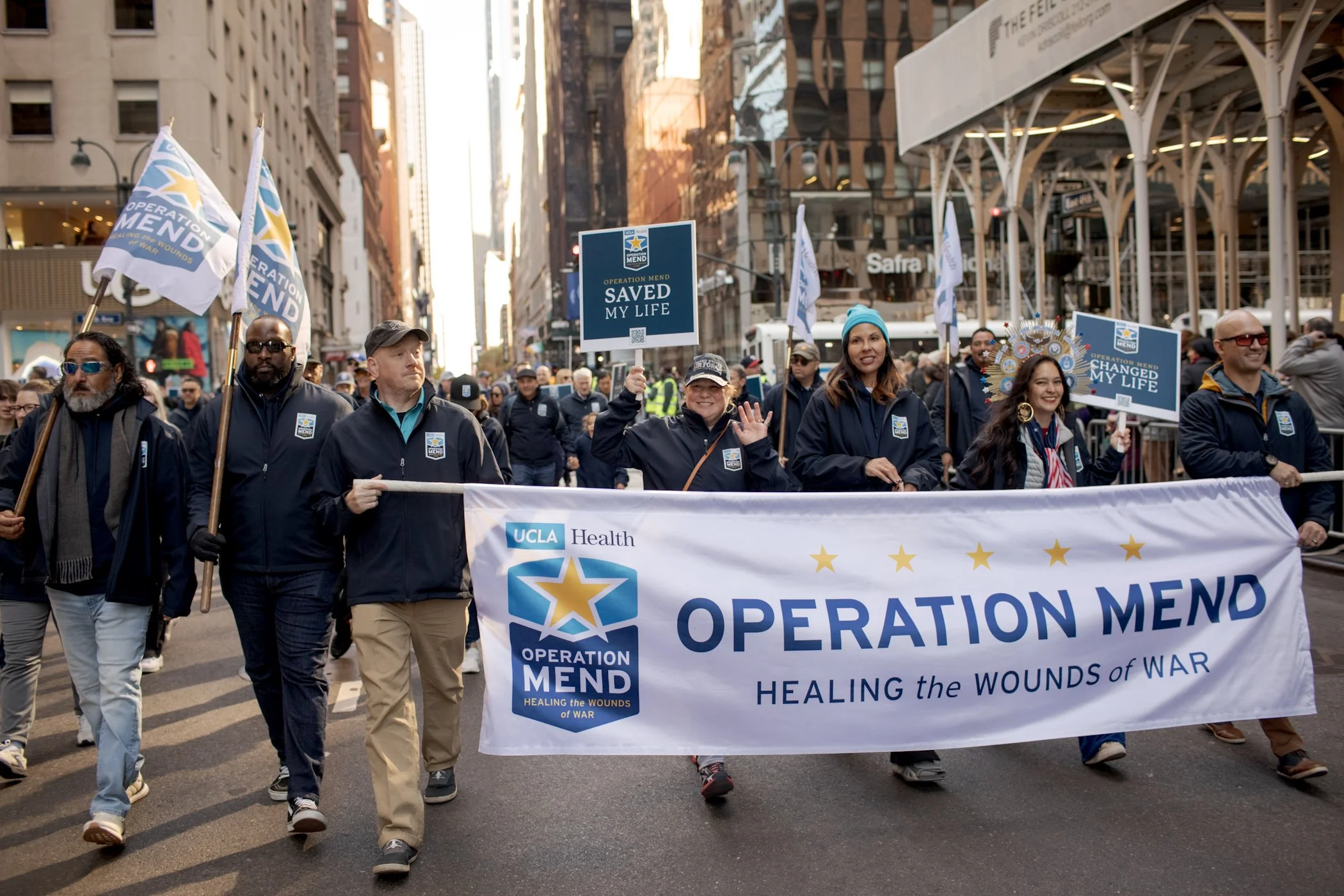 Operation Mend members walking in a street parade in New York with signs and banner.