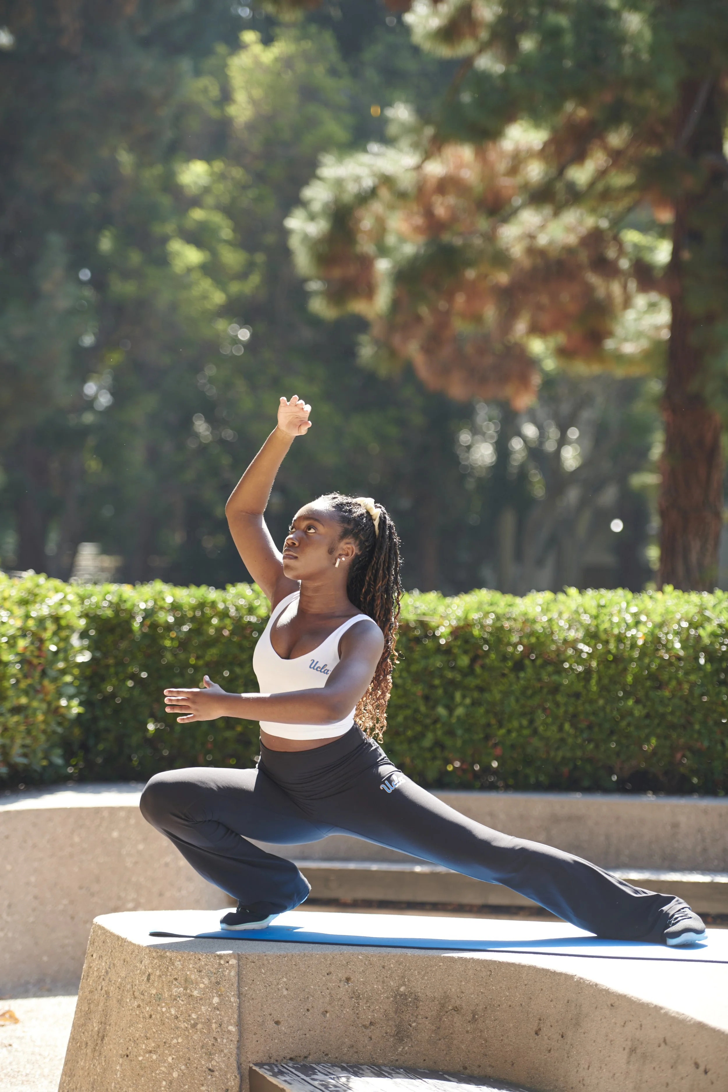 A woman doing a yoga pose in a UCLA x Lululemon workout top