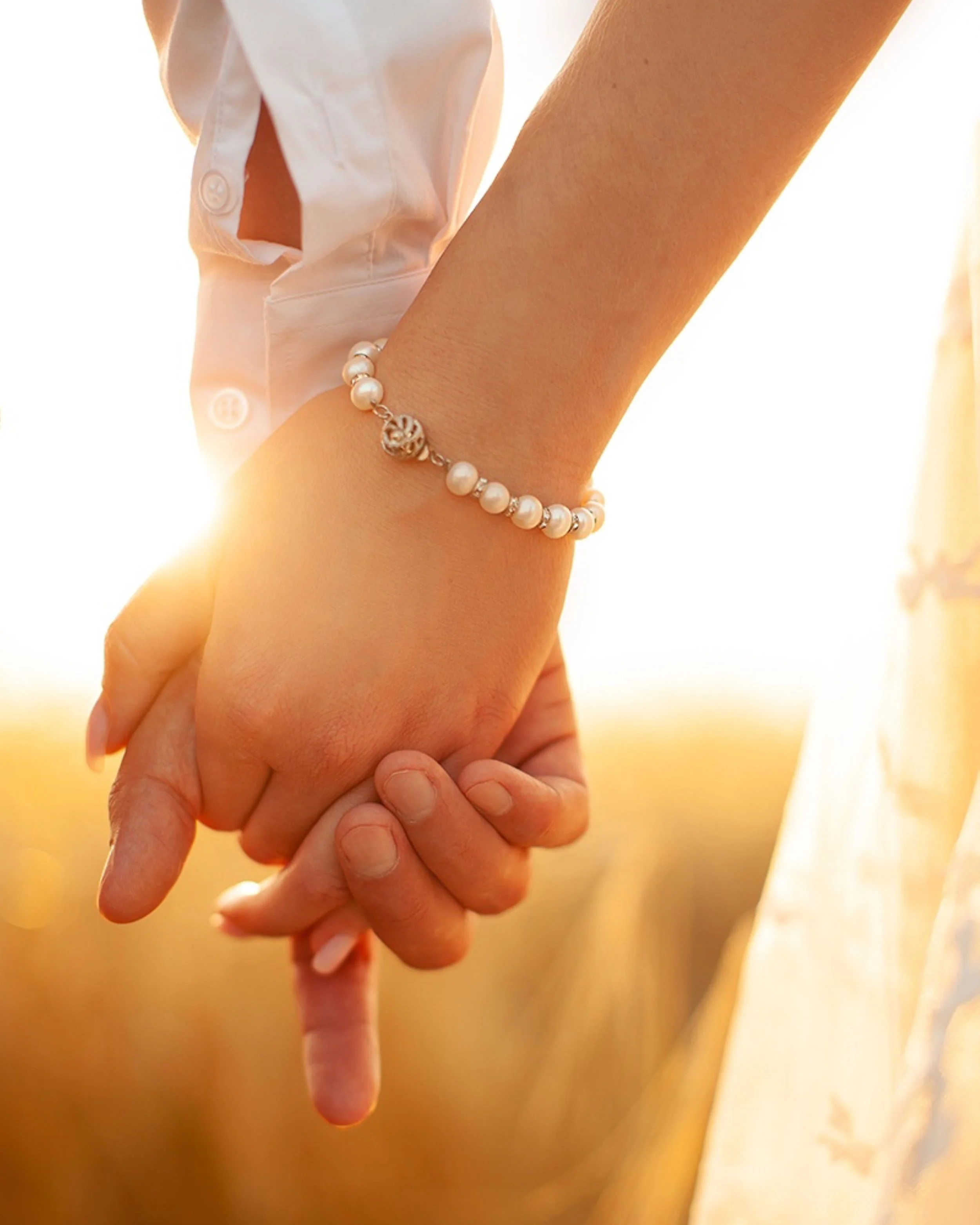 closeup photo of two people holding hands.