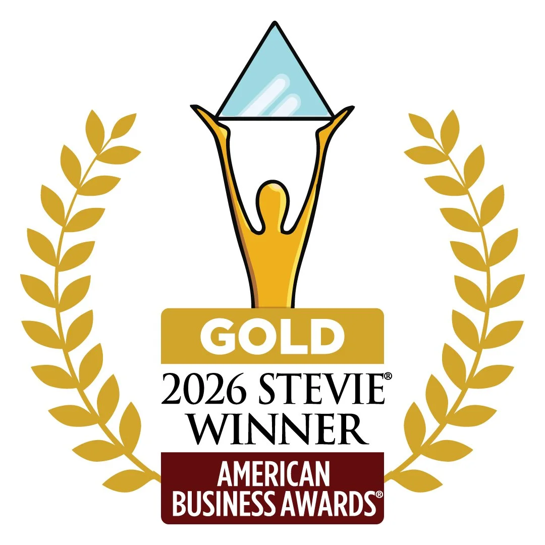 This logo depicts a gold American Business Award of a gold person holding a glass triangle. Text below reads "Gold 2026 Stevie Winner American Business Awards," framed by leaf details.
