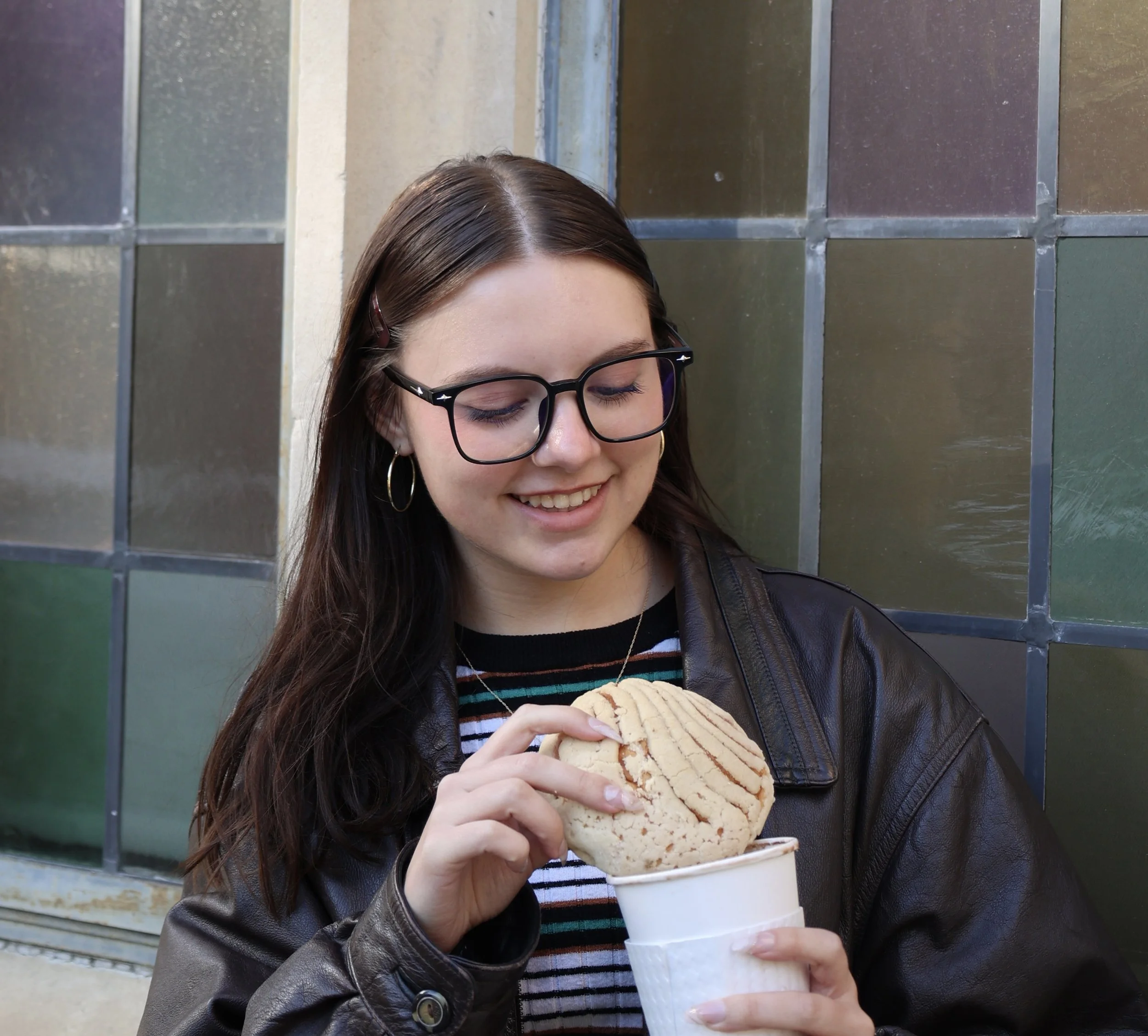 Woman holds cookie in white paper cup