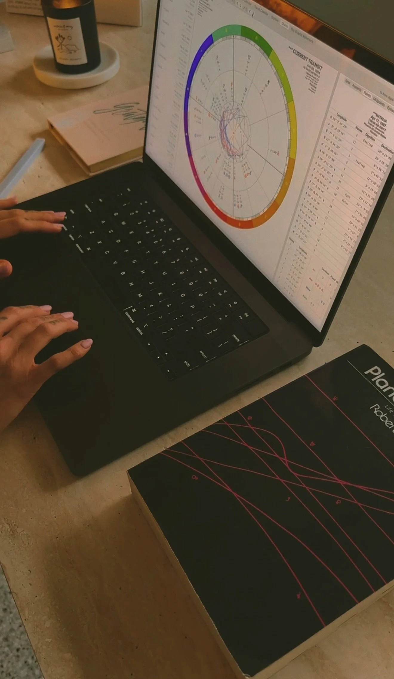 typing on a computer and reading a natal chart