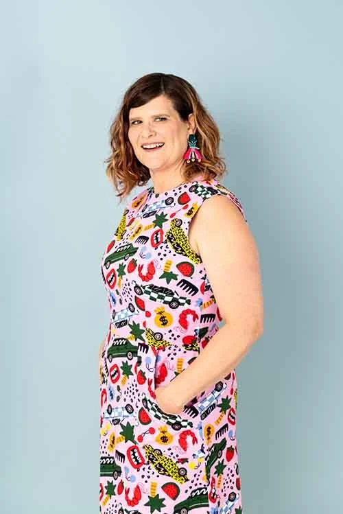 Crescent in a colorful patterned dress, looking to the right.