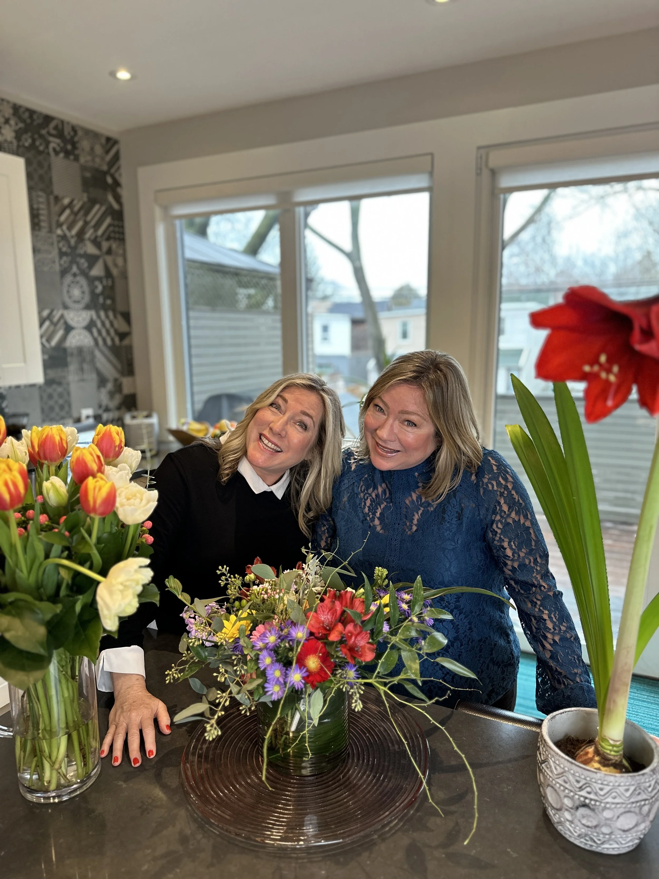 Fiona and Sarah Carver are in a home surrounded by flowers.