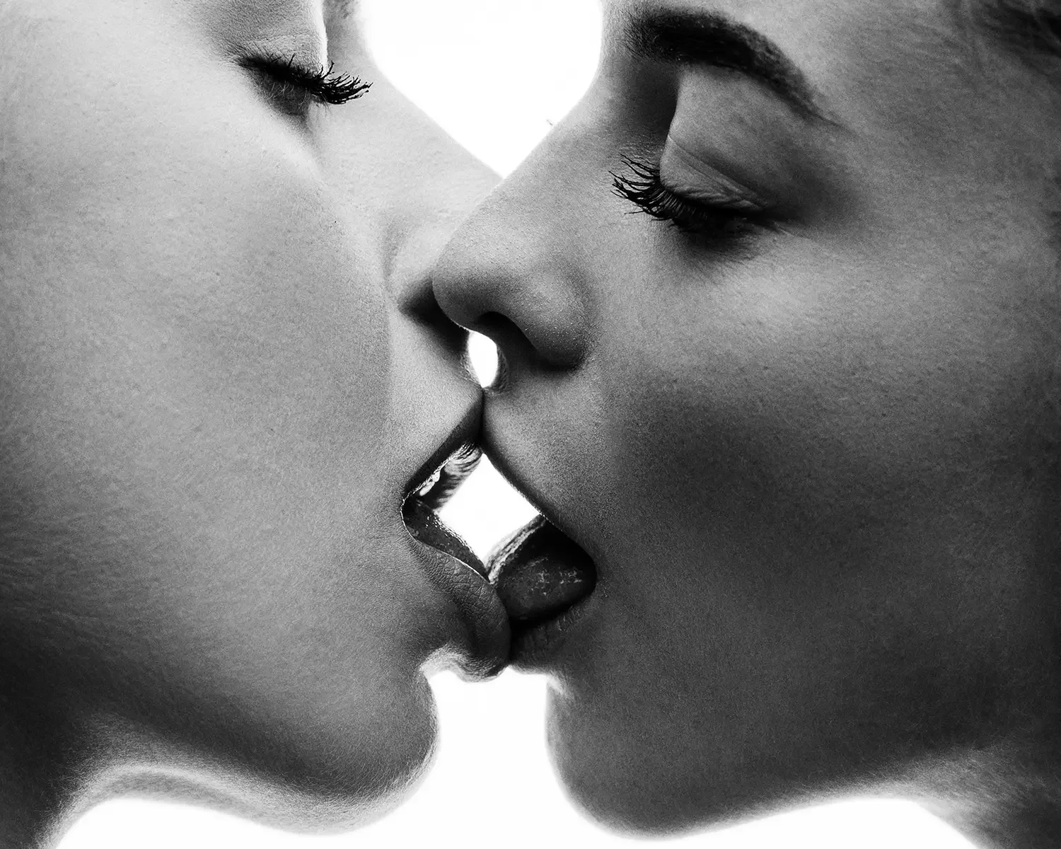 intense and provocative sensual kiss of two young women captured as close up