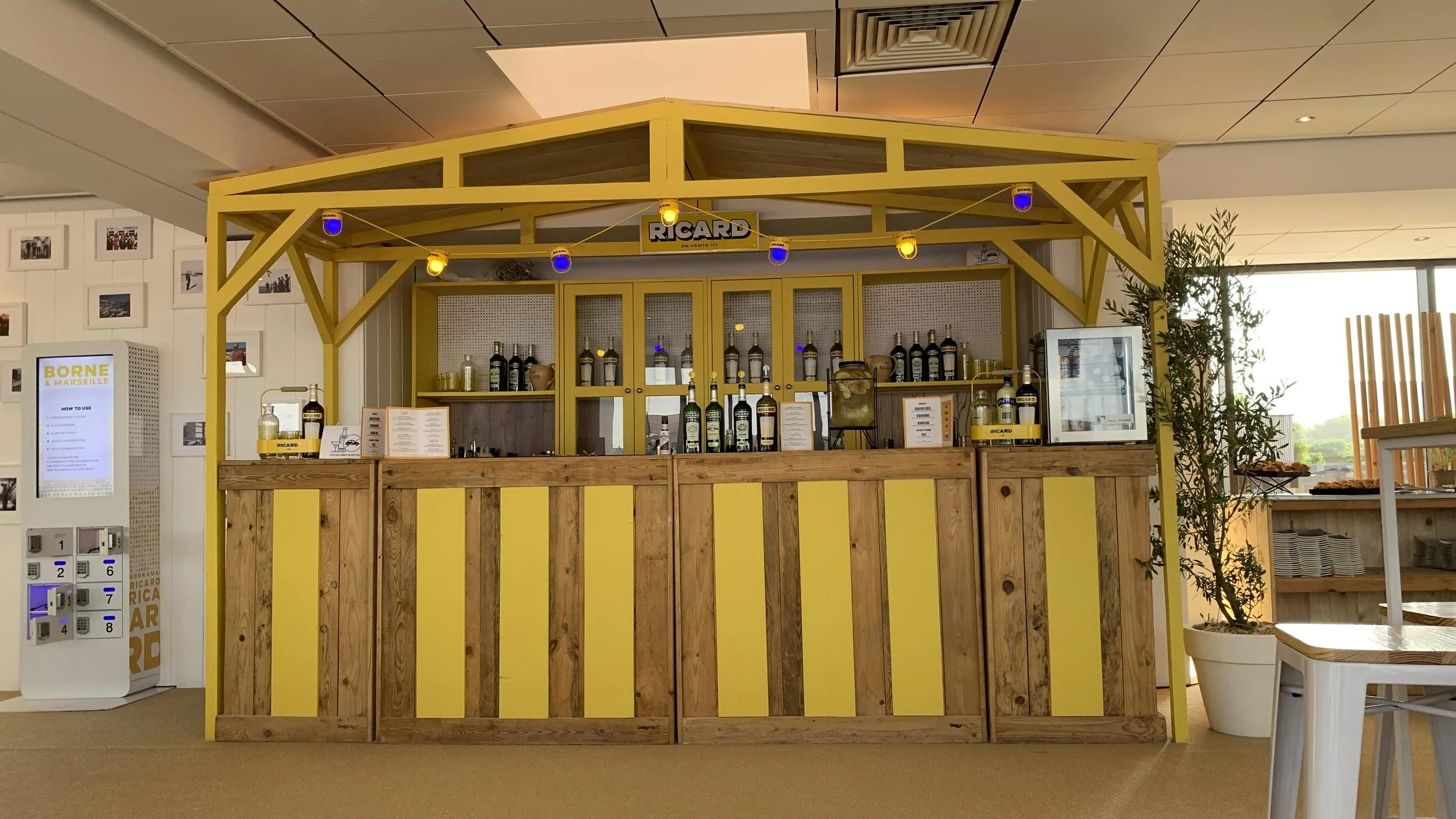 Bar en bois jaune avec étagères de bouteilles d'alcool.