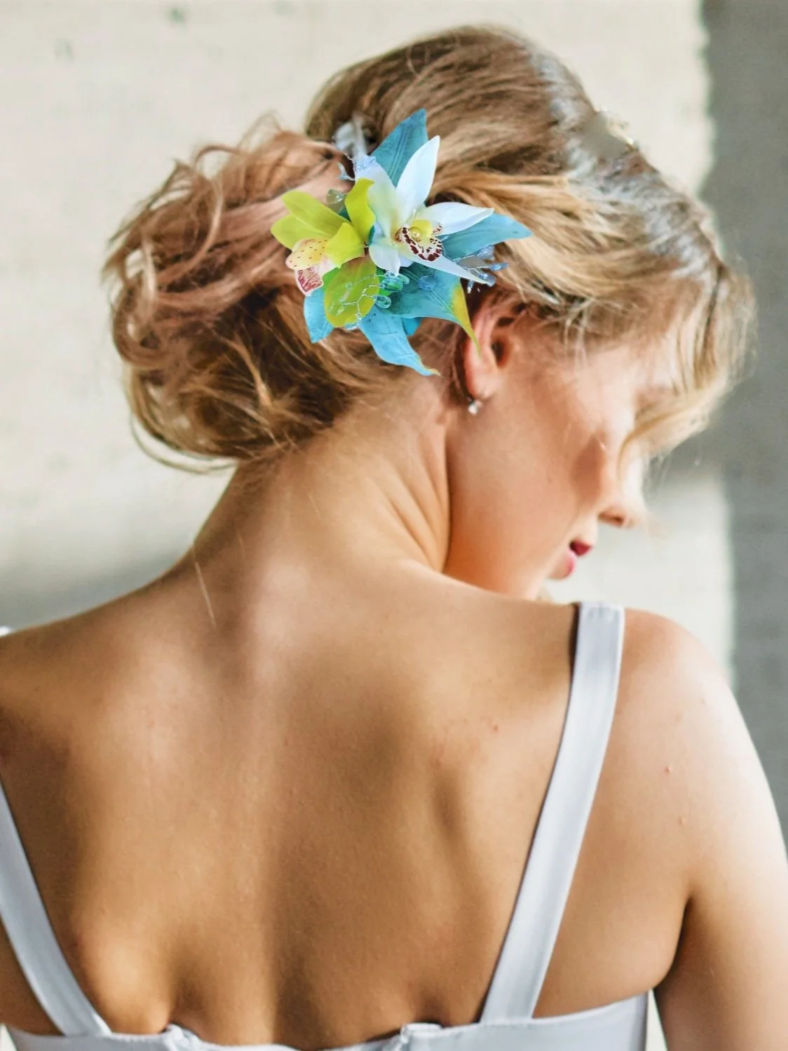 Bride wearing tropical orchid hair clip with crystals