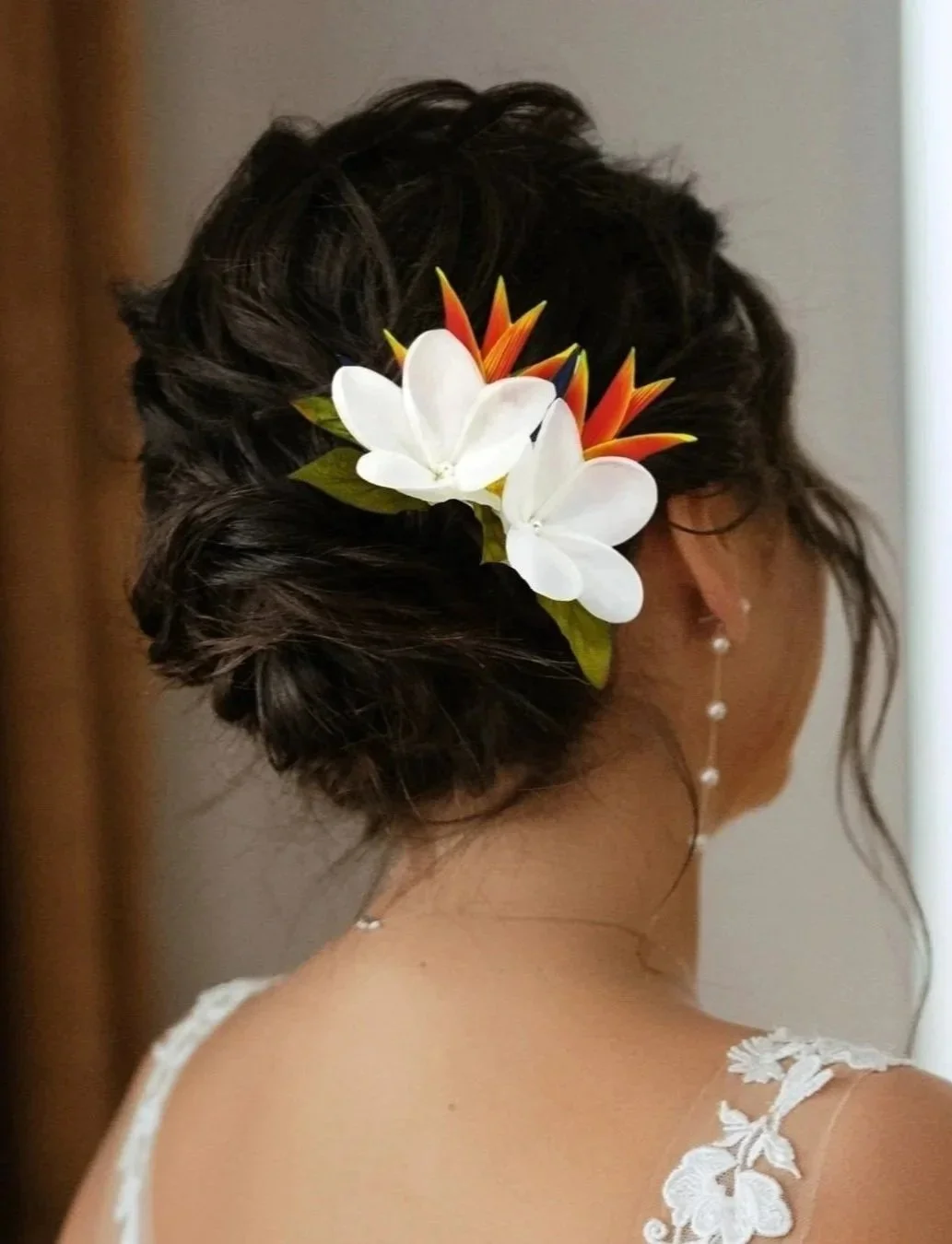 Bride wearing tropical flower headpiece with heliconia and plumeria
