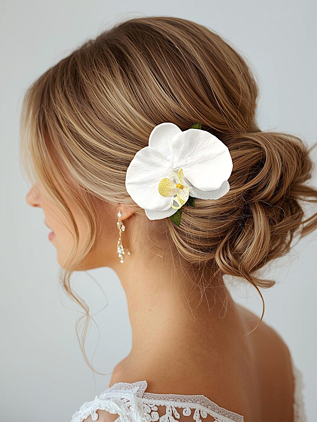 Bride wearing silk white orchid hair flower with pearl
