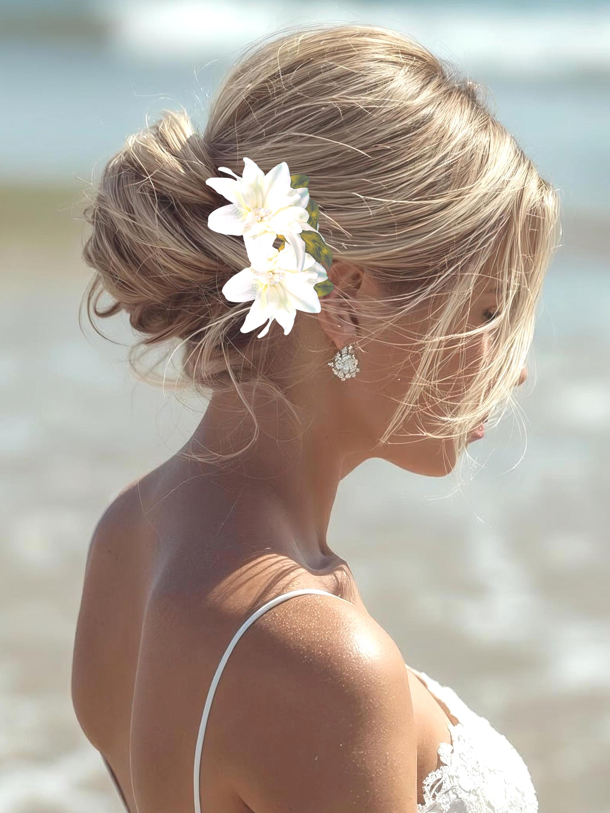 Bride on beach wearing silk white wedding hair flower