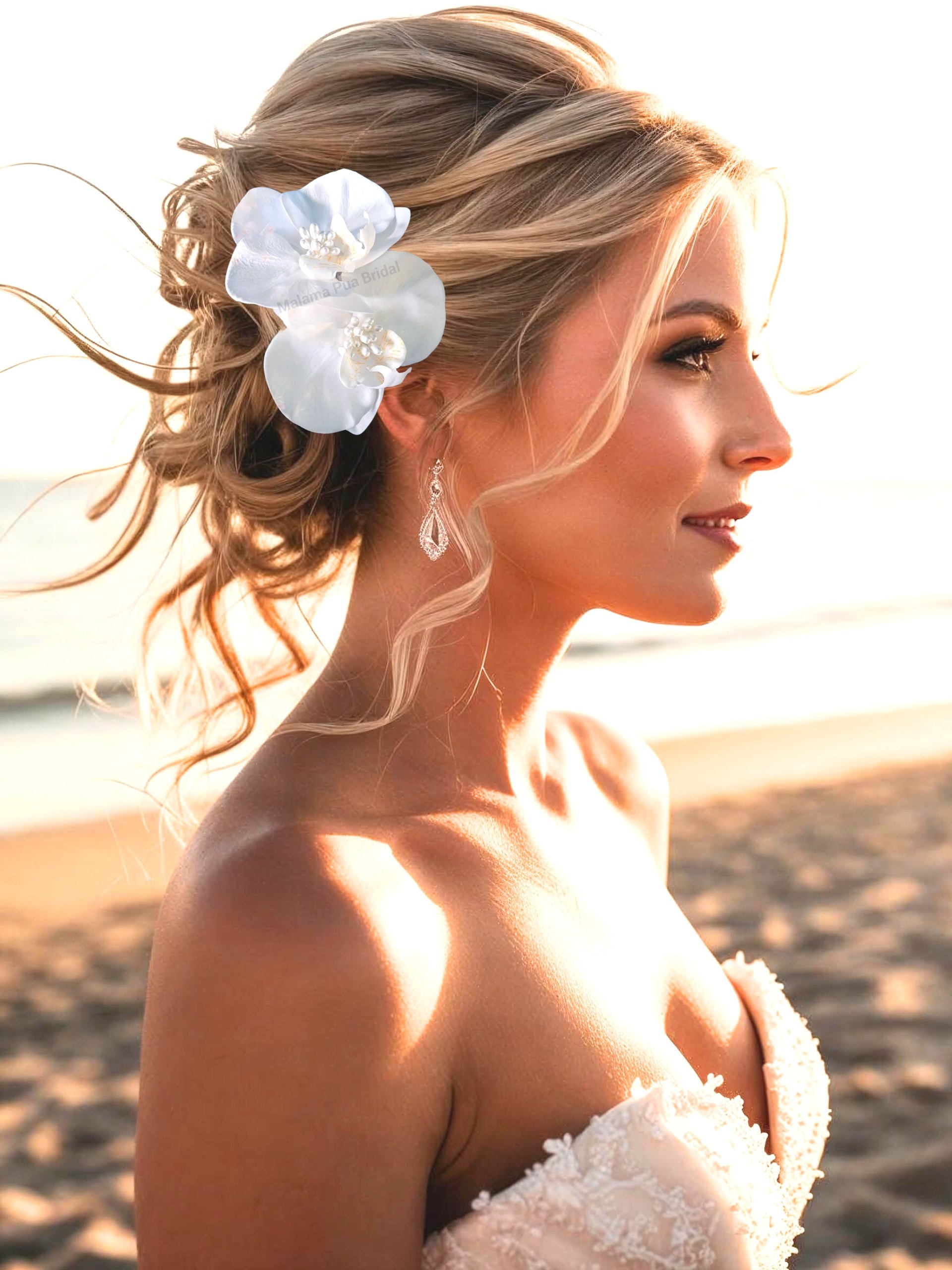 Bride on beach wearing silk white orchid headpiece with pearls