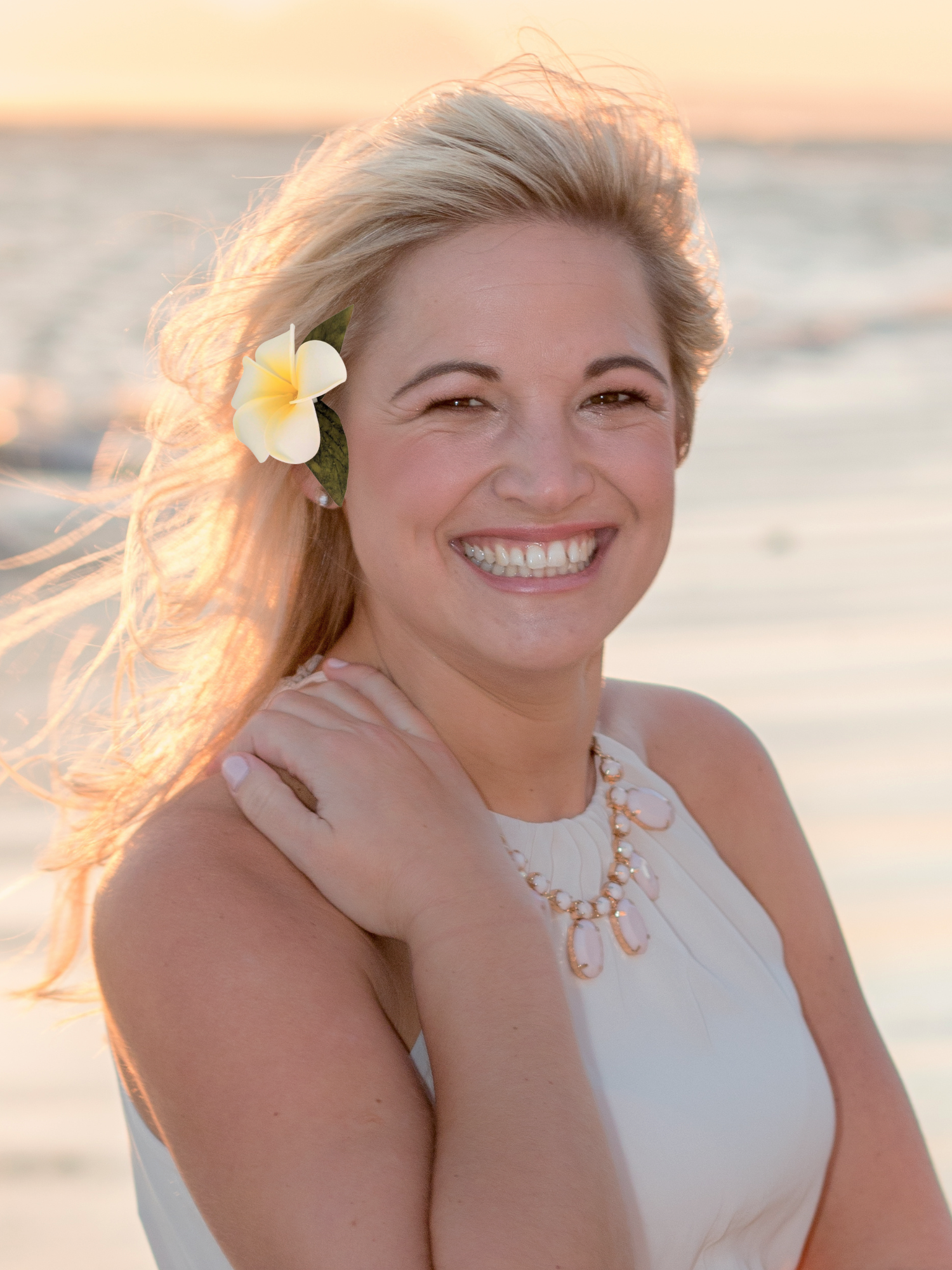 bride on beach wearing single plumeria foam hair clip