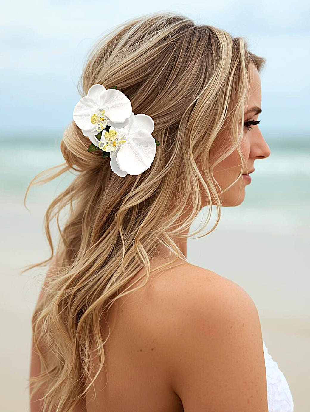 Bride on beach wearing silk white orchid hair flower with pearl