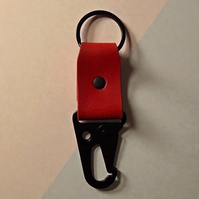 Full-grain leather key clip with sturdy metal clasp, perfect for attaching keys to bags or belts.