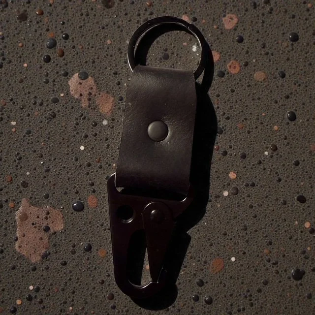 Full-grain leather key clip with sturdy metal clasp, perfect for attaching keys to bags or belts.