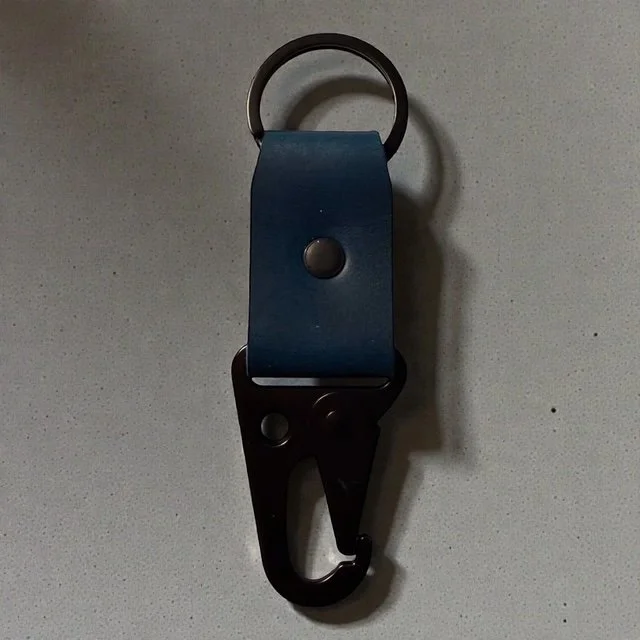 Full-grain leather key clip with sturdy metal clasp, perfect for attaching keys to bags or belts.