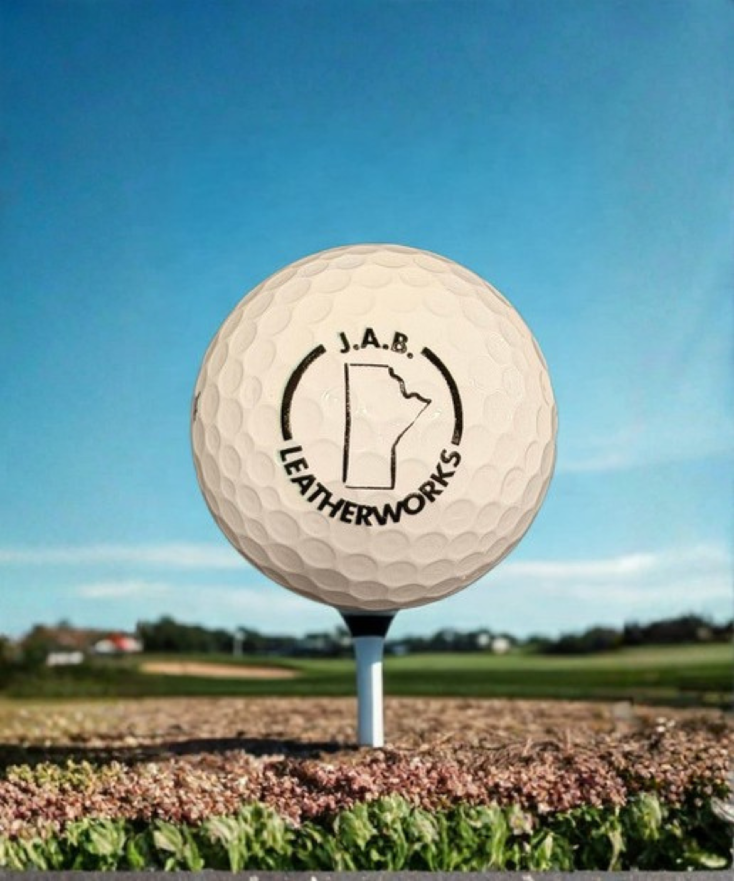 White golf ball printed with JAB Leatherworks Logo