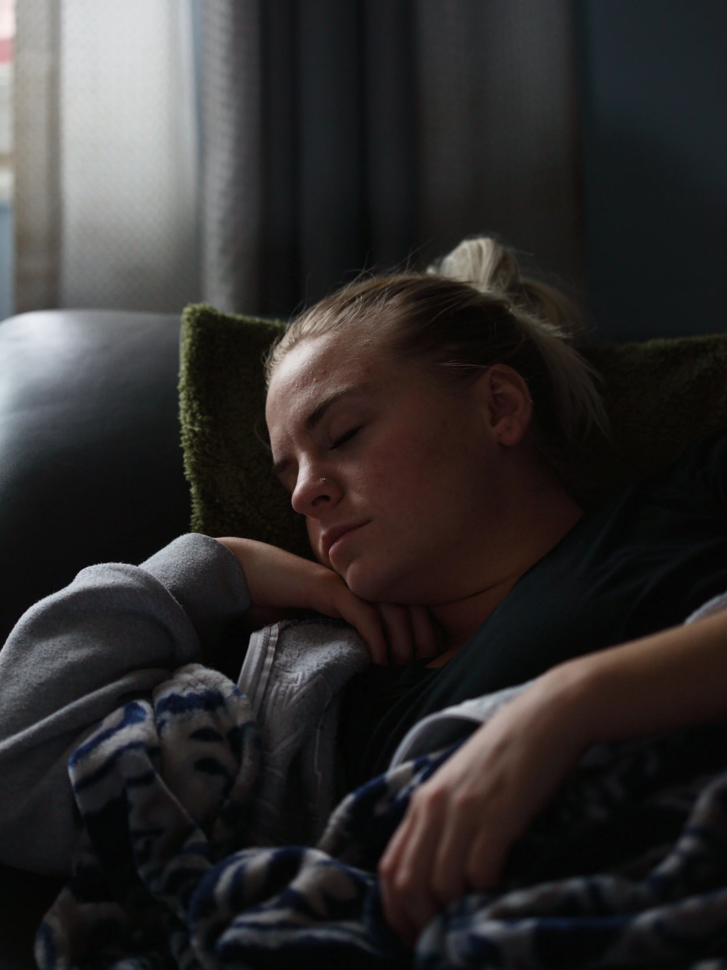 Woman laying down on a sofa, tired